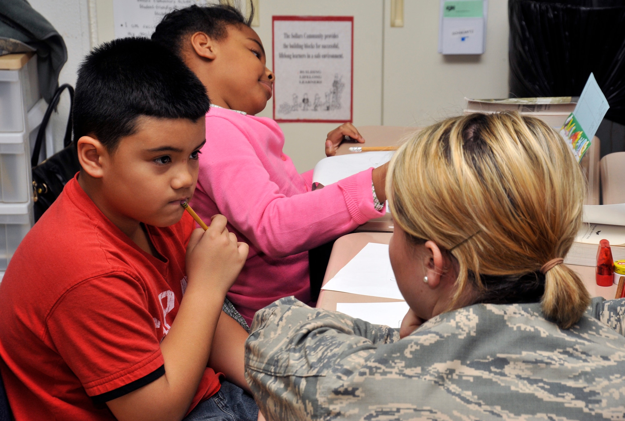 U.S. Air Force 1st Lt. Caitlin Suttie, 35th Fighter Wing Public Affairs chief and Dragon Academy volunteer, helps a Sollars Elementary School third grader during a writing class at Misawa Air Base, Japan, Feb. 13, 2013. The Dragon Academy is an opportunity for the base community to volunteer at the school to help students in various subjects. If you want to volunteer at the Dragon Academy, contact Sollars at 226-3933 for more information. (U.S. Air Force photo by Airman 1st Class Zachary Kee)