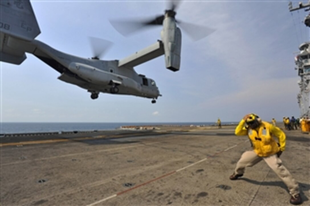 Chief Petty Officer Patrick Dewberry braces himself ¬against the rotor wash of a MV-22 Osprey launching from the deck of the amphibious assault ship USS Bonhomme Richard (LHD 6) in the Gulf of Thailand on Feb. 19, 2013.  The Bonhomme Richard Amphibious Ready Group is deployed in the U.S. 7th Fleet area of responsibility and is taking part in Cobra Gold 2013, a Thai-U.S. co-sponsored multinational joint exercise.  