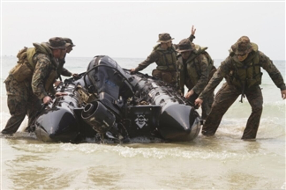 U.S. Marines and sailors with the 1st Marine Expeditionary Unit drag a combat rubber raiding craft into position after coming ashore during a boat raid as part of exercise Cobra Gold 2013 in Thailand on Feb. 15, 2013.  Cobra Gold is an annual exercise that includes events ranging from amphibious assaults to non-combatant evacuation operations.  The training aims to improve interoperability between the United States, the Kingdom of Thailand, and other participating countries.  