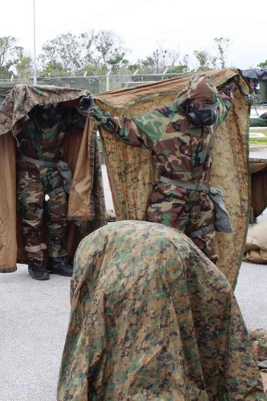 Marines with 3rd Intelligence Battalion respond to a simulated chemical, biological, radiological and nuclear spray attack Feb. 14 at Camp Hansen. The Marines learned how to respond to different types of CBRN attacks during a five-day CBRN defense course. 3rd Intel. Bn. is a part of III Marine Expeditionary Force Headquarters Group, III MEF.