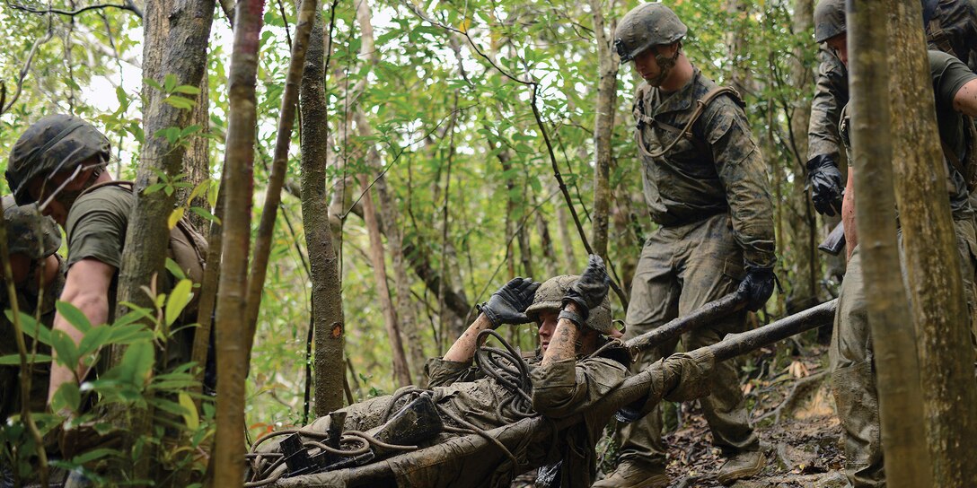 Lance Cpl. Gregory N. Hager, center, is evacuated Feb. 15 at the Jungle Warfare Training Center during the endurance course. The course emphasized small-unit leadership, getting junior Marines to take charge to accomplish their squad’s mission. Hager is a military policeman with 3rd LE Bn. 