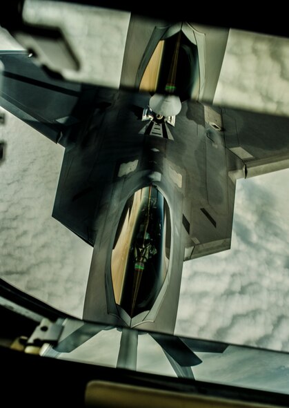 A KC-135 Stratotanker refueling aircraft refuels an F-22 Raptor during a training sortie near Kadena Air Base, Japan, Feb. 19, 2013. Raptors from Joint Base Langley-Eustis, Va., are deployed to Kadena to promote stability and security in the pacific region. (U.S. Air Force Photo/Airman 1st Class Tyler Prince.)