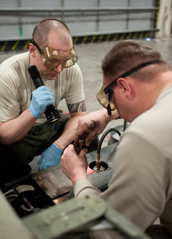 Tech. Sgt Robert Holyoke (left), 28th Munitions Squadron support equipment technician, and Tech. Sgt Christopher Shields, 28th Munitions Squadron trailer maintenance NCO in charge, release the master cylinder as the last step of emptying brake fluid from a munitions trailer at Ellsworth Air Force Base, S.D., Feb. 7, 2013. The master cylinder is bled after each drum to ensure all brake lines have been cleared of air to guarantee the brakes work properly. (U.S. Air Force photo by Airman 1st Class Alystria Maurer/Released)