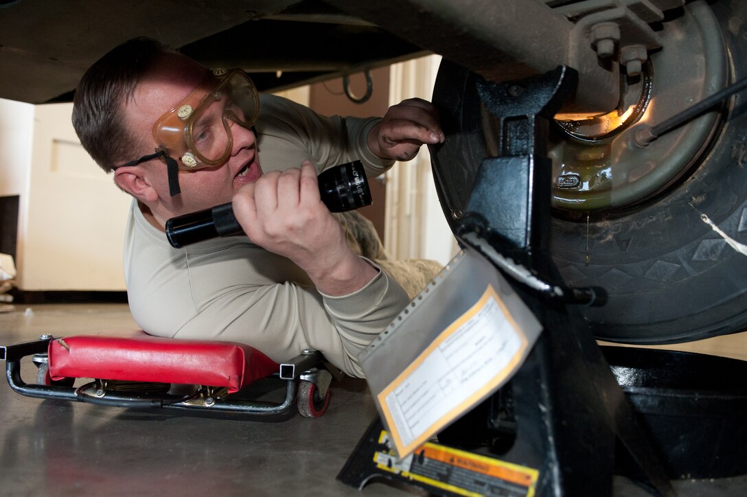 Tech. Sgt Christopher Shields, 28th Munitions Squadron trailer maintenance NCO in charge, releases a valve to empty brake fluid from a munitions trailer at Ellsworth Air Force Base, S.D., Feb. 7, 2013. Each drum must be bled of brake fluid to ensure all air is removed from the lines which guarantees constant pressure in the hydraulic system. (U.S. Air Force photo by Airman 1st Class Alystria Maurer/Released)