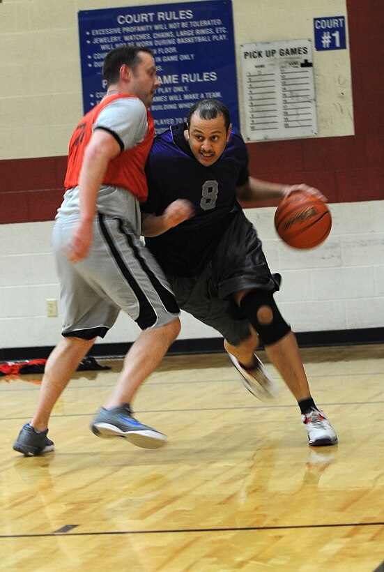 Senior Airman De Angelo Simons, 28th Logistics Readiness Squadron command support staff technician, drives past a defender during the base 2013 Intramural Basketball League tournament in the Bellamy Fitness Center at Ellsworth Air Force Base, S.D., Feb. 19, 2013. Games are scheduled Monday through Friday from 5 to 8 p.m., and will continue until March 16. (U.S. Air Force photo by Airman 1st Class Hrair H. Palyan/Released)