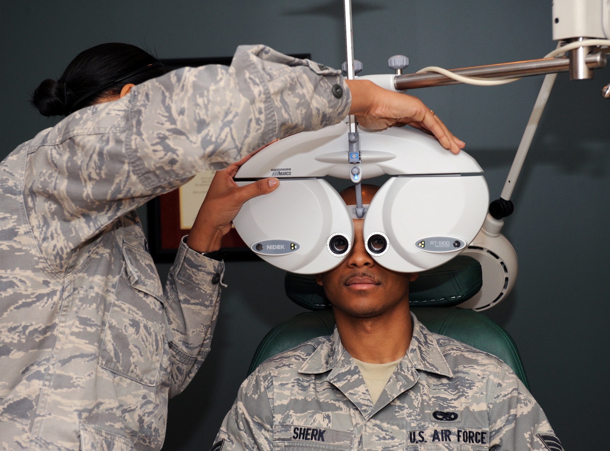 Maj. Stephanie King, 2nd Aerospace Medicine Squadron optometrist, places a phoropter in front of Senior Airman Deven Sherk, 2nd Maintenance Squadron phase support, at the Optometry Clinic on Barksdale Air Force Base, La., Feb. 20. The phoropter contains different lenses for each eye, which helps the optometrist find the correct prescription for the patient. (U.S. Air Force photo/Airman 1st Class Benjamin Gonsier)

