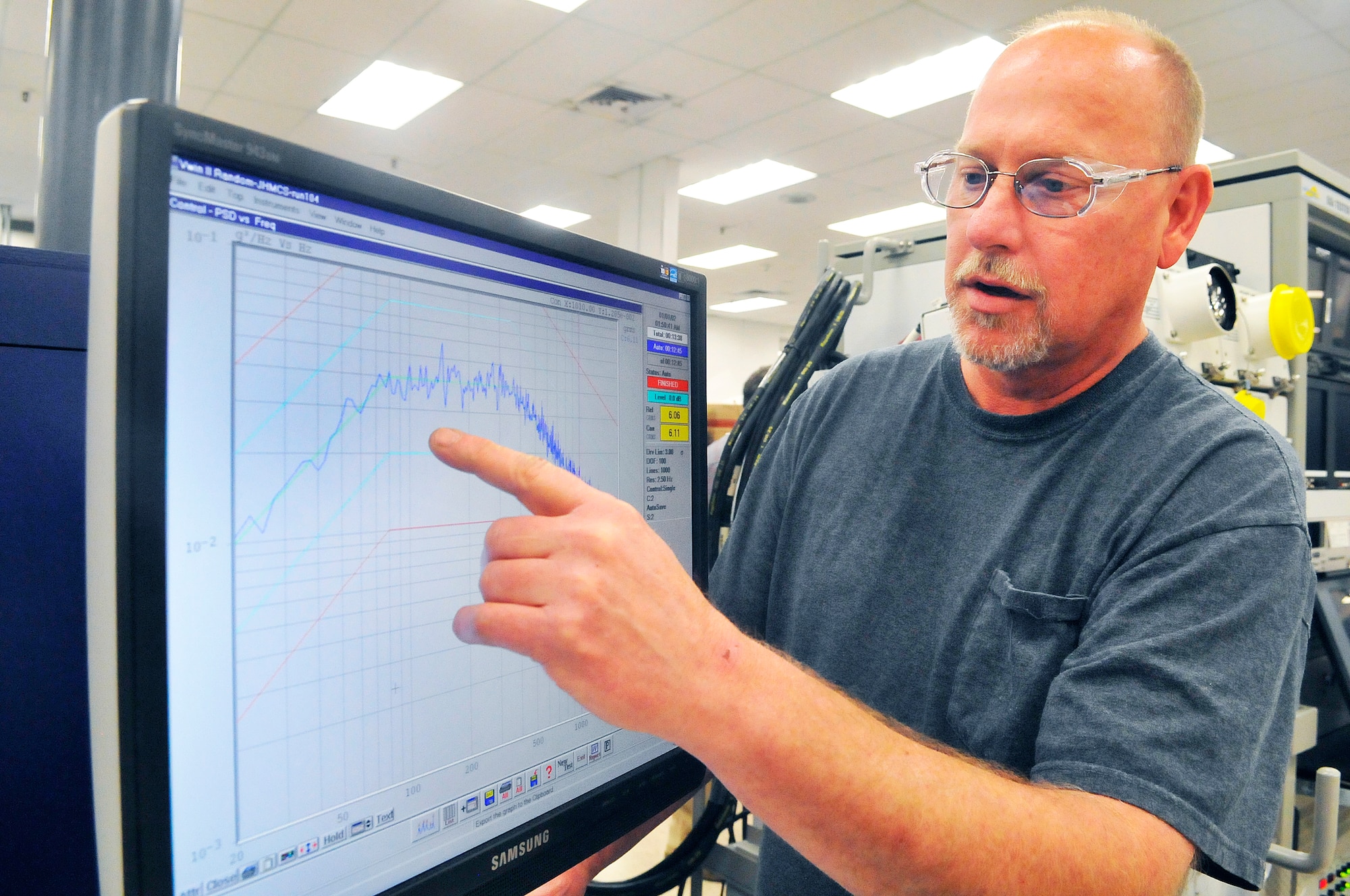 Roger Cain, integrated electronics systems mechanic, shows a screen where an electronic unit processor for the Joint Helmet Mounted Cueing System has gone through a vibration chamber test. (U. S. Air Force photo/Sue Sapp)