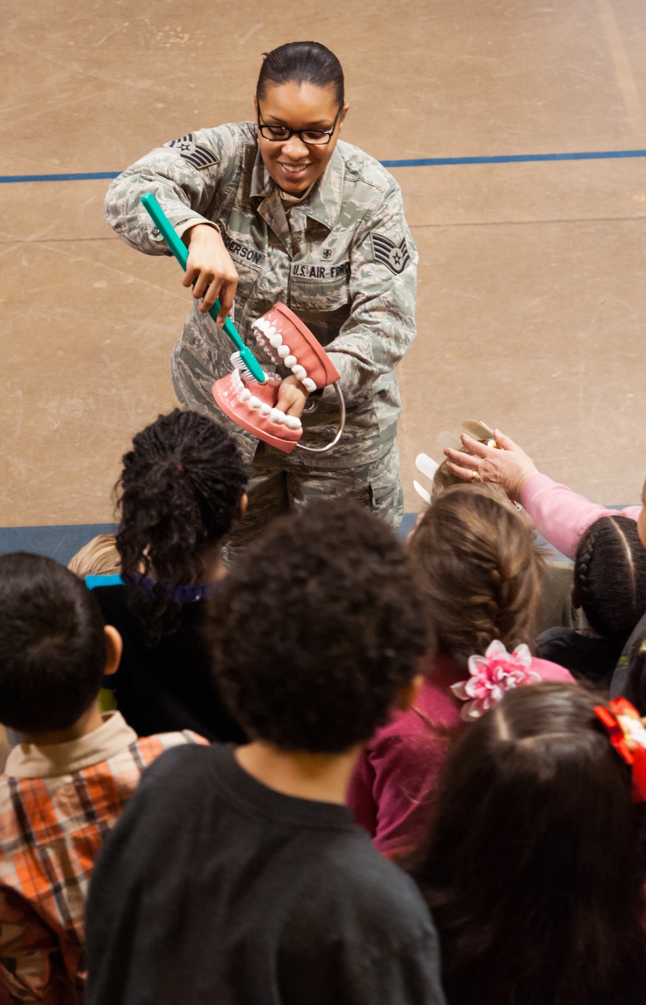 Staff Sgt. Octavia Henderson, 87th Dental Squadron dental hygienist, demonstrates to children the correct way to brush teeth at the Children’s Dental Health Month event Feb. 11, 2013, at Lakehurst Elementary School in Lakehurst, N.J. The program is designed to educate children on proper oral hygiene, cavity prevention and gum disease.  Henderson hails from Newark, N.J. (U.S. Air Force photo by Russ Meseroll/Released)