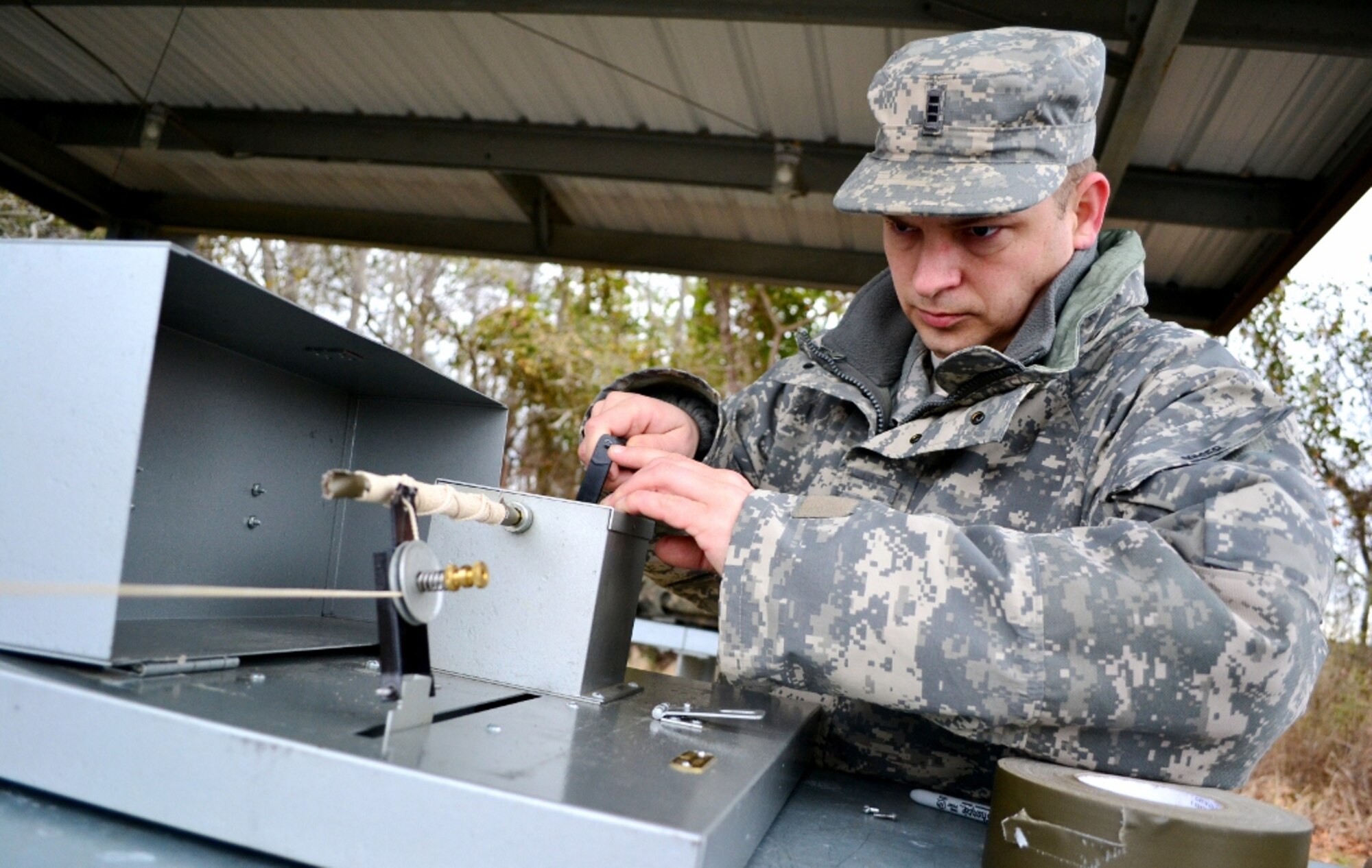 U.S. Army Chief Warrant Officer Thomas Spicer, assigned to Headquarters & Headquarters Company, Special Troops Battalion, 7th Sustainment Brigade, winds up a roll of string using a mechanical spooling device during a test fire of .45 caliber modified pistol ammunition at Fort Eustis, Va., Feb. 13, 2013. The ammunition must be tested before being equipped on vessels throughout the Army watercraft field. (U.S. Army photo by Sgt. Edwin Rodriguez/Released)
