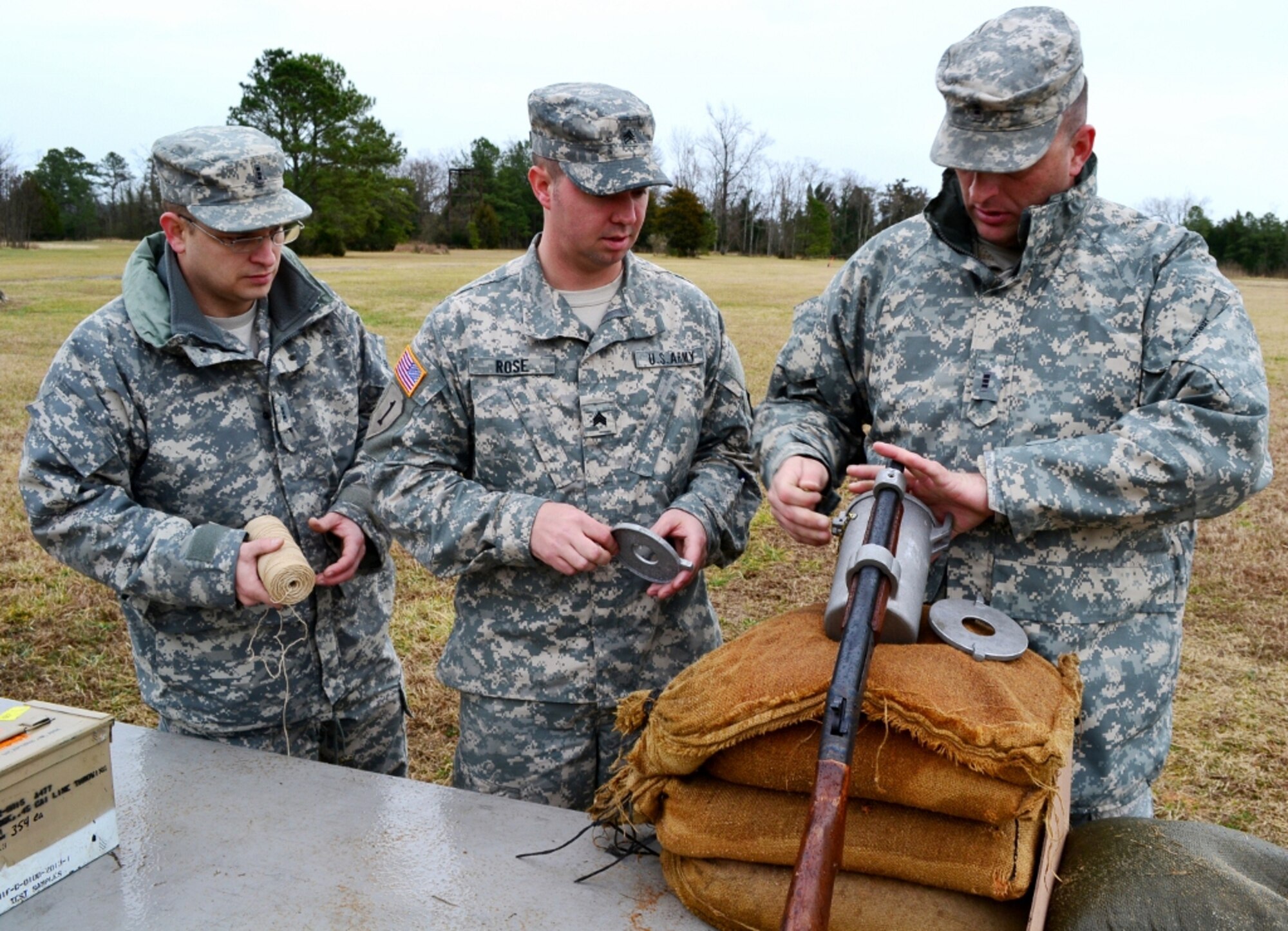 (From left) U.S. Army Chief Warrant Officer Thomas Spicer, Sgt. Bryan Rose, and CWO Joseph Swartout work together to load up a Bridger Line Throwing Appliance with string, .45 caliber modified pistol ammunition and a metal rod while on a test fire range at Fort Eustis, Va., Feb. 13, 2013. This group of Soldiers assigned to the 7th Sustainment Brigade is testing the ammunition before the possibility of equipping vessels throughout the Army watercraft field with Bridgers. (U.S. Army photo by Sgt. Edwin Rodriguez/Released)