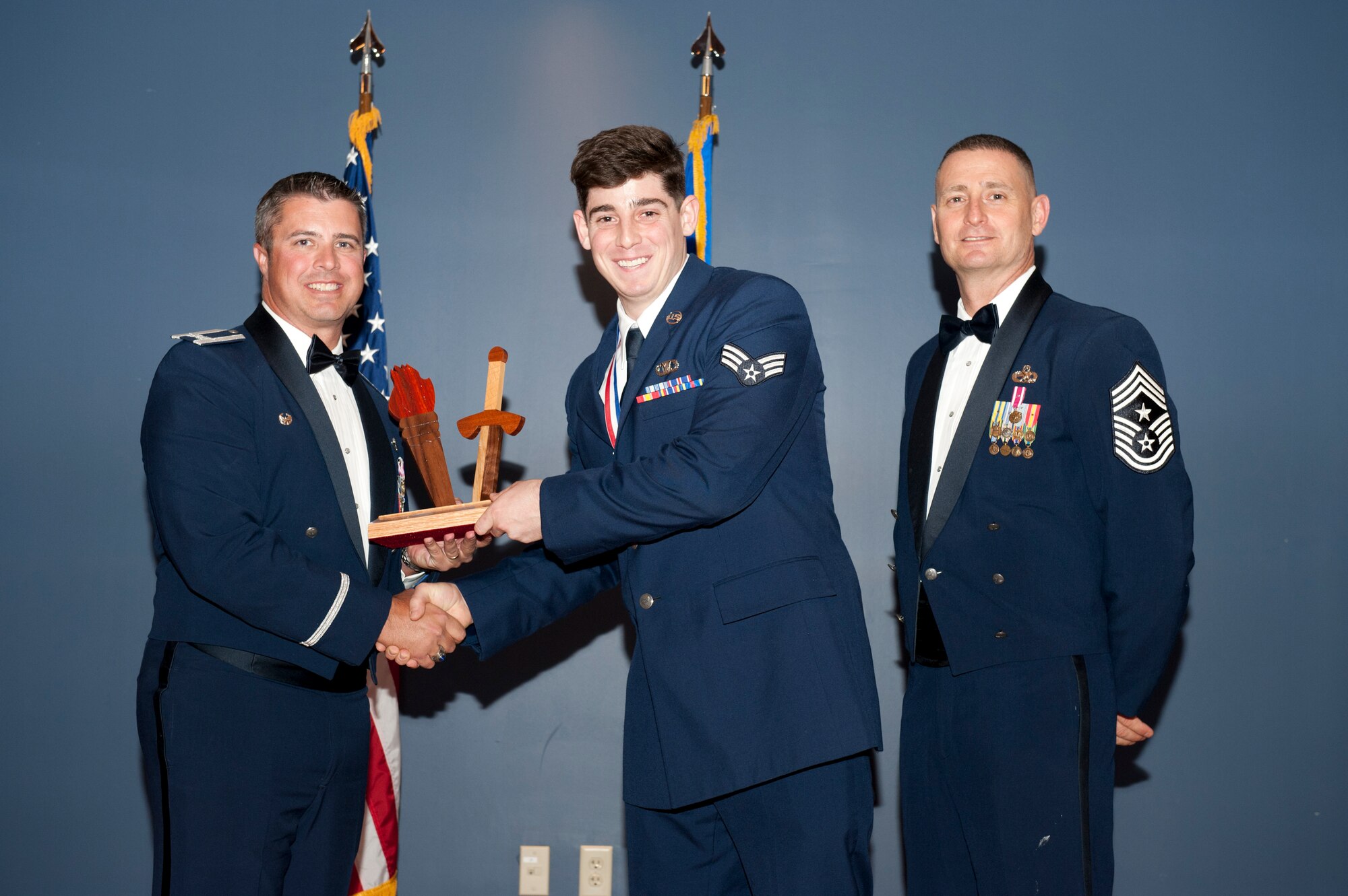 Senior Airman Nicholas Brison, Tyndall Honor Guard, receives the 2012 Team Tyndall Annual Award for Honor Guard Member of the Year Feb. 20 from Col. David Graff, 325th Fighter Wing commander and Chief Master Sgt. Ray DeVite, 325th FW command chief. (U.S. Air Force photo by Lisa Norman)