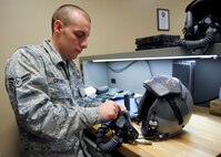 U.S. Air Force Airman 1st Class Sean Crowell, aircrew flight equipment technician with the 23d Operations Support Squadron, uses waxed thread to secure an oxygen mask to a pilot’s helmet during the certifying and fitting of the Helmet Mounted Cueing System (HMCS) at Moody Air Force Base, Ga., Jan. 17, 2013. The HMCS is the world’s only full-color helmet display system, and it will be fielded downrange by Airmen from the 74th Fighter Squadron in the A-10C Thunderbolt II for the first time. (U.S. Air Force photo by Senior Airman Eileen Meier/Released)