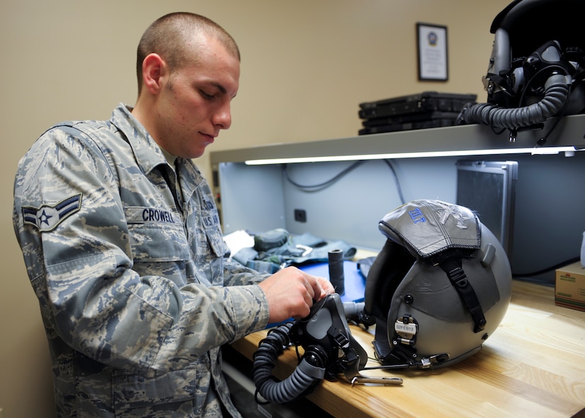 U.S. Air Force Airman 1st Class Sean Crowell, aircrew flight equipment technician with the 23d Operations Support Squadron, uses waxed thread to secure an oxygen mask to a pilot’s helmet during the certifying and fitting of the Helmet Mounted Cueing System (HMCS) at Moody Air Force Base, Ga., Jan. 17, 2013. The HMCS is the world’s only full-color helmet display system, and it will be fielded downrange by Airmen from the 74th Fighter Squadron in the A-10C Thunderbolt II for the first time. (U.S. Air Force photo by Senior Airman Eileen Meier/Released)