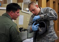 U.S. Air Force Airman 1st Class Sean Crowell, 23d Operations Support Squadron aircrew flight equipment technician, works with Capt. James Schmidt, 81st Fighter Squadron at Spangdahlem, Germany, A-10C Thunderbolt II pilot, by preparing his helmet for the installation of the Helmet Mounted Cueing System, during a mass fitting for A-10 pilots in the Air Flight Equipment section at Moody Air Force Base, Ga., Jan. 17, 2013.  Schmidt was here for a temporary duty assignment to fly with the 74th Fighter Squadron and to be certified and fitted for the HMCS, which will be used for the first time downrange by Moody Airmen. (U.S. Air Force photo by Senior Airman Eileen Meier/Released)
