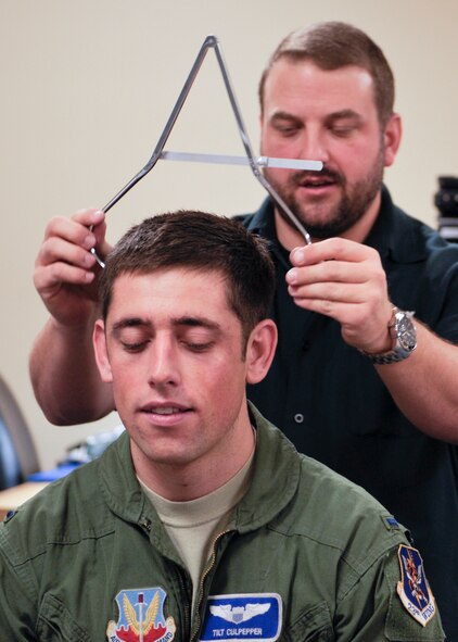 Scott Smither, GENTEX® Corporation technical specialist, retrieves head measurements from U.S. Air Force 1st Lt. Elijah Culpepper, 74th Fighter Squadron A-10C Thunderbolt II pilot, using a spreading caliper at Moody Air Force Base, Ga., Jan. 17, 2013.   A mass fitting was held for 74th FS A-10C Thunderbolt II pilots who will be fielding the Helmet Mounted Cueing System for the first time downrange. (U.S. Air Force photo by Senior Airman Eileen Meier/Released)