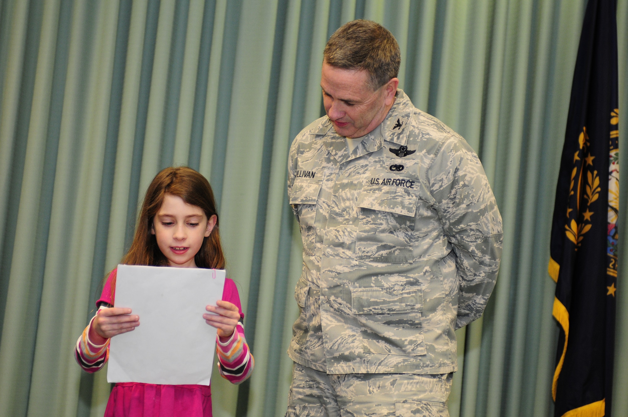 Zoe Selig, an elementary student from Moharimet Elementary School in Madbury, N.H, reads a letter of support for basing the Boeing KC-46A air refueling tanker at Pease Air National Guard Base to Col. Peter Sullivan, 157th Air Refueling Wing Vice Commander, Pease Air National Guard Base, N.H., Feb 20, 2013.  The letter was signed by 59 students. (National Guard photo by Tech. Sgt. Aaron P. Vezeau/Released)