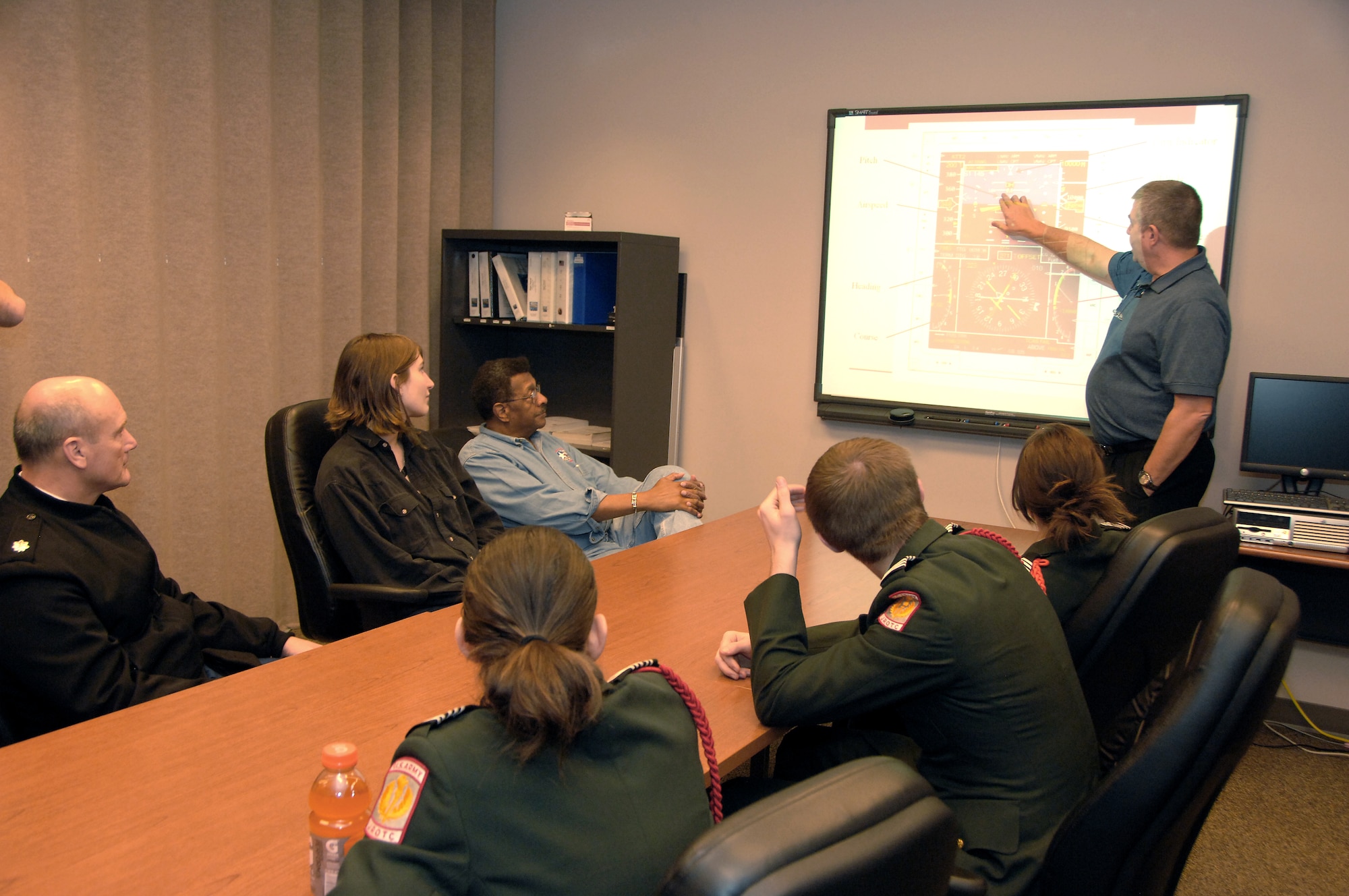 Omaha Benson High School JROTC cadets receive instruction from Todd Clark, 338th Combat Training Squadron instructor pilot, on the basic controls of an RC-135V/W Rivet Joint aircraft inside a conference room at Offutt Air Force Base, Neb., Feb. 14. The students were participating in a program organized by the Alfonza W. Davis chapter of Tuskegee Airmen, Inc., designed to stimulate youth interest in science, technology, engineering and math. (U.S. Air Force photo by Delanie Stafford/Released)