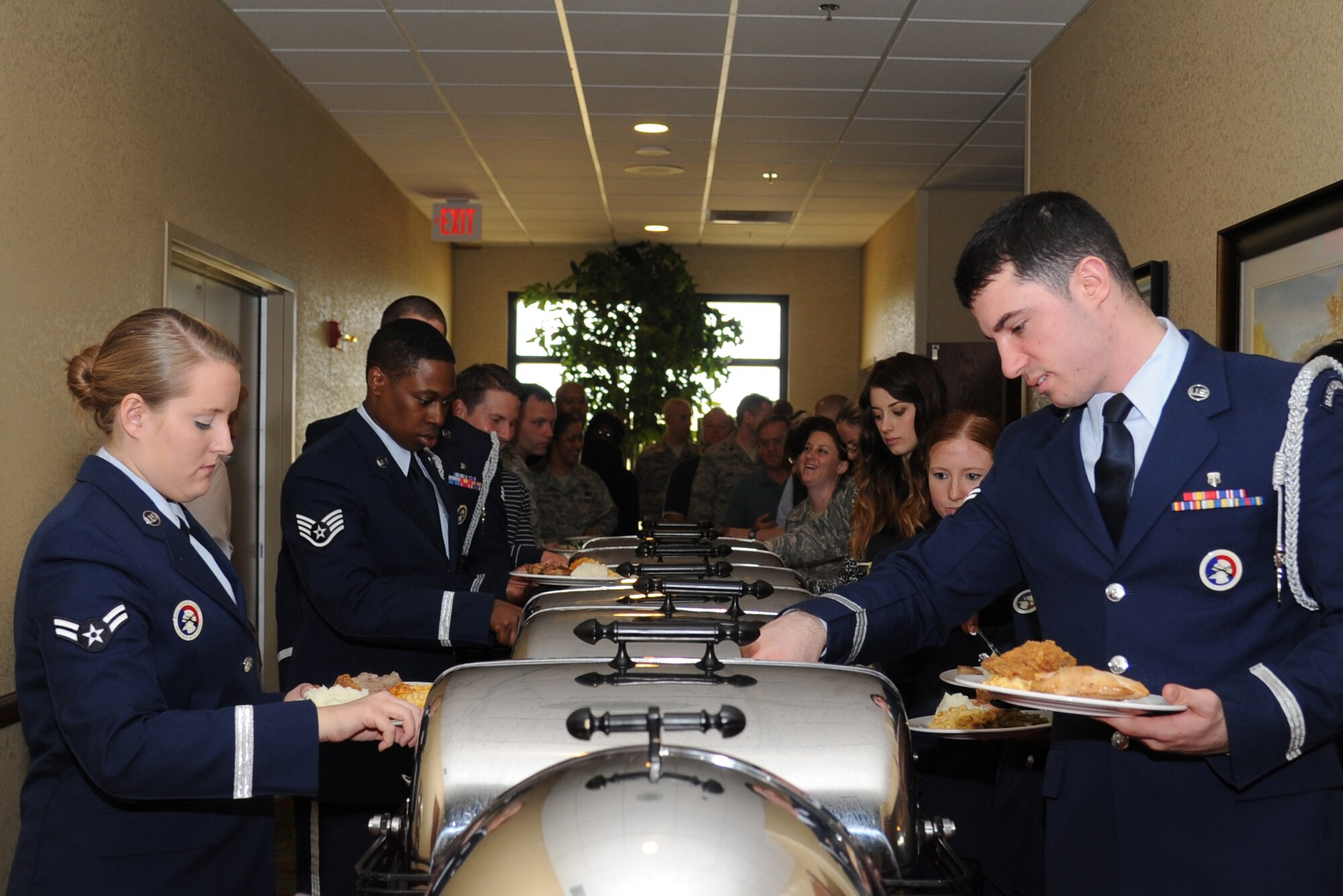 Airmen 1st Class Madison Rossi and Brayden Van Bever, Keesler Honor Guard members, help themselves to the buffet line at the National Prayer Luncheon Feb. 20, 2013, at the Bay Breeze Event Center, Keesler Air Force Base, Miss.  The event included a ceremony by the Keesler Honor Guard to honor prisoners of war and those missing in action and a guest speaker, retired Col. Richard Toliver. The annual event, a tradition that stems back to President Dwight D. Eisenhower in 1953, allows individuals of different faiths and backgrounds to join together to reflect and develop their spiritual fitness. This year’s theme was “Pray for America.”  (U.S. Air Force photo by Kemberly Groue)