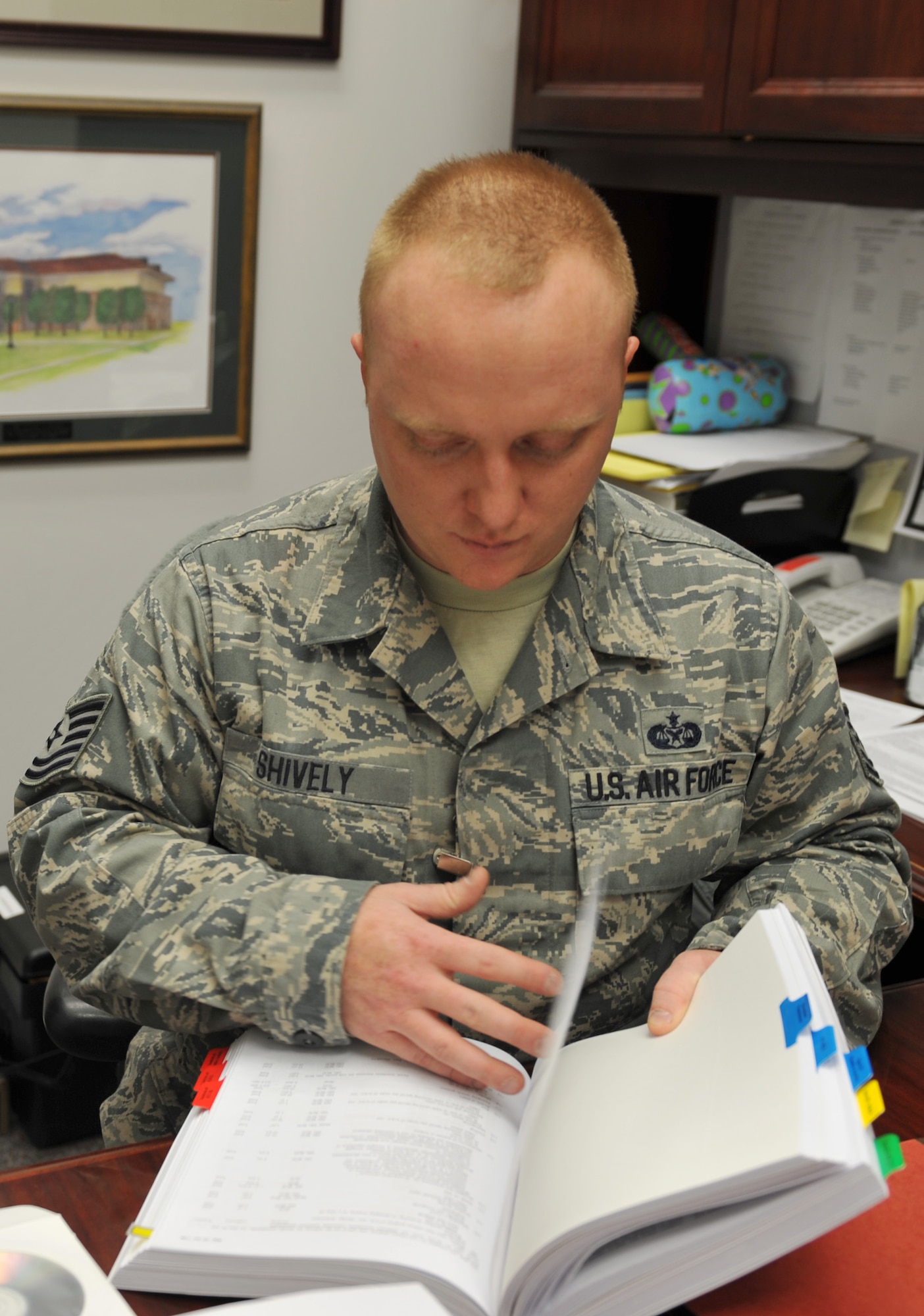 WHITEMAN AIR FORCE BASE, Mo. -- Tech. Sgt. Matthew Shively, 509th Bomb Wing Legal Military Justice NCO in charge, does research on legal issues during his shift at the 509th Bomb Wing Legal Office, Feb. 19, 2013. Shively refers to the book often to prepare for upcoming cases and real-world issues. (U.S. Air Force photo/Heidi Hunt)