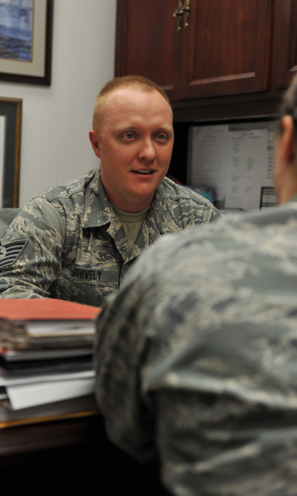 WHITEMAN AIR FORCE BASE, Mo. -- Tech. Sgt. Matthew Shively, 509th Bomb Wing Legal Military Justice NCO in charge, speaks with a Team Whiteman member during his shift at the Whiteman AFB Legal Office. Shively’s legal experience and leadership allows him to ensure mission readiness and military discipline. (U.S. Air Force photo/Heidi Hunt)