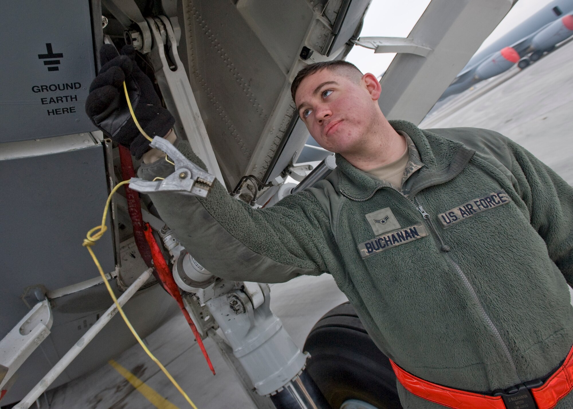 Airman 1st Class David Buchanan, 728th Air Mobility Squadron Operating Location-Alpha crew chief, grounds a C-17 Globemaster III Feb. 21, 2013, at Transit Center at Manas, Kyrgyzstan. Buchanan is deployed from Dover Air Force Base, Del., and is a native of Mesa, Ariz. (U.S. Air Force photo/Staff Sgt. Stephanie Rubi)