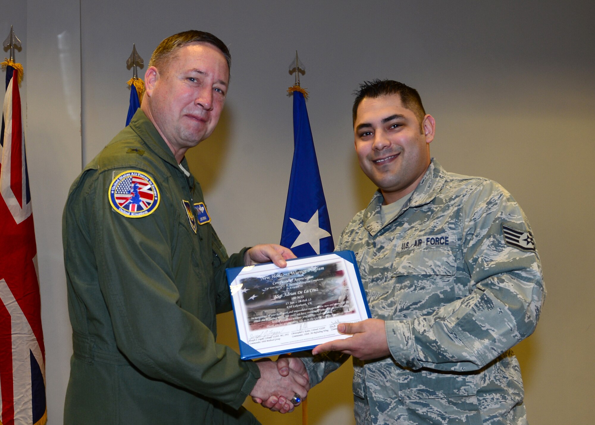 ROYAL AIR FORCE LAKENHEATH, England - Staff Sgt. Adrian De La Cruz, 100th Maintenance Squadron vehicle control NCO from RAF Mildenhall, is presented with a New Horizons graduation certificate by Brig. Gen.  Jon Norman, Director to United States Air Forces in Europe-United Kingdom, Feb. 19, 2013. De La Cruz was one of 14 Airmen from the 48th Fighter Wing and 100th Air Refueling Wing that graduated from the New Horizons Wounded Warrior Support Program. (U.S. Air Force photo by Staff Sgt. Stephanie Mancha)
