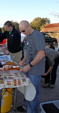 Tech. Sgt. Justin Triola, 17th Airlift Squadron loadmaster, distributes portions of pasta to persons in need as part of the Charleston Random Acts of Kindness Feb. 8, 2013, in downtown Charleston, S.C. The 17th AS has been supporting Charleston Random Acts of Kindness with the Feed a Friend Friday event for more than a year. Squadron members can be regularly seen serving on the food line when their flying schedules permit. (Courtesy photo)