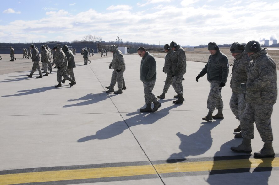 Airmen of the 193rd Special Operations Wing participate in a foreign object debris walk on the flightline in Middletown, Pa. Feb. 9, 2013. FOD walks are done to keep aircraft safe from damage that could occur from any debris. (U.S. Air Force Photo by Tech. Sgt Culeen Shaffer/Released)