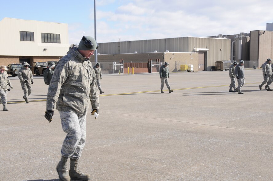 Tech. Sgt. Todd Schroll leads a group of 193rd Special Operations Wing Airmen in a foreign object debris walk on the flightline in Middletown, Pa. Feb. 9, 2013. FOD walks are done to keep aircraft safe from damage that could occur from any debris. (U.S. Air Force Photo by Tech. Sgt Culeen Shaffer/Released)