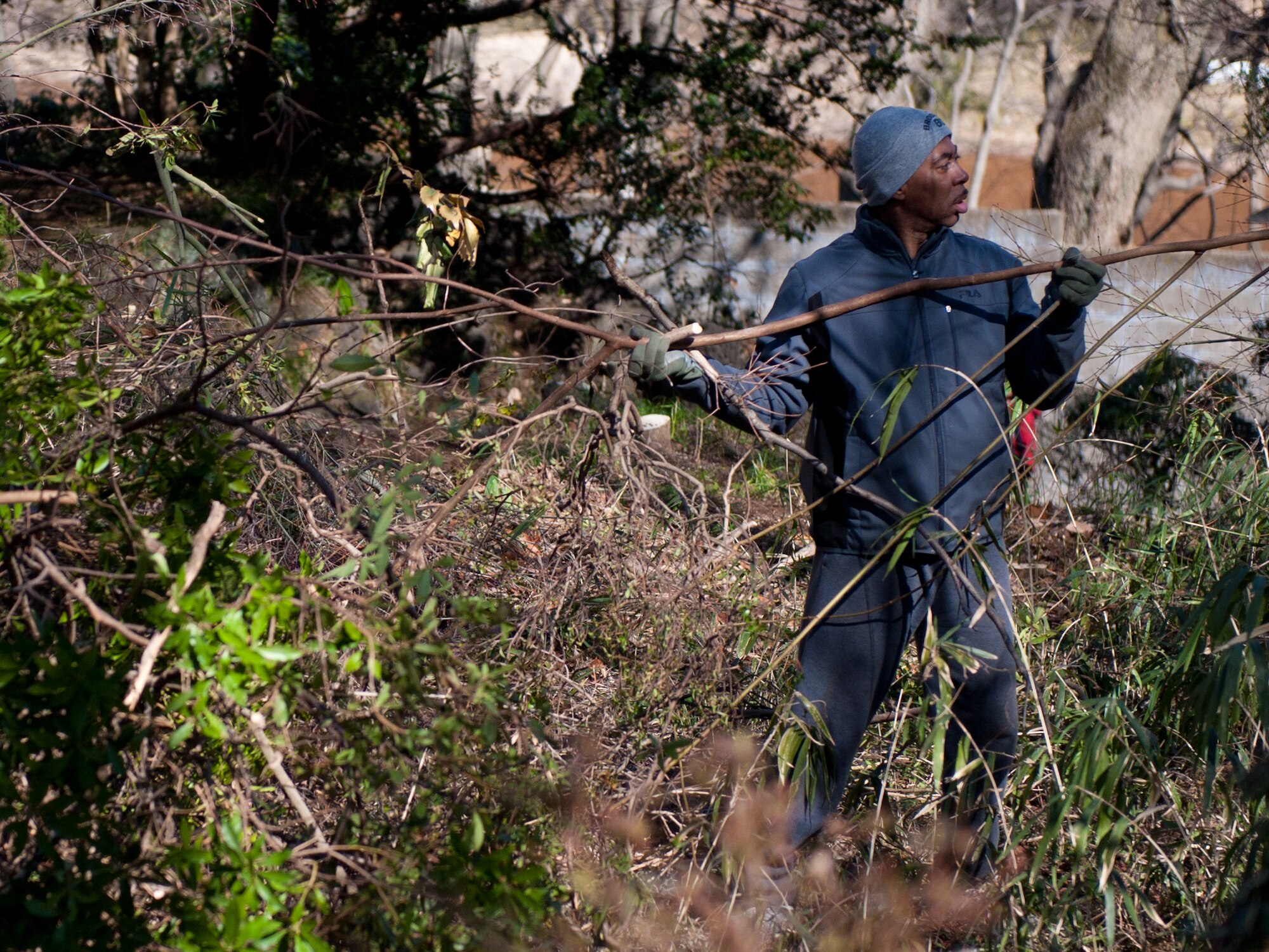 Andre Greenet, a Yokota Air Base volunteer, clears branches from a debris pile outside the Monastery of St. Clare near Yokota Air Base, Japan, Feb. 16, 2013. Greenet and other members of the Yokota Catholic Community helped recovered overgrown areas to support the local sisters. (U.S. Air Force photo by 1st Lt. Christopher Love)