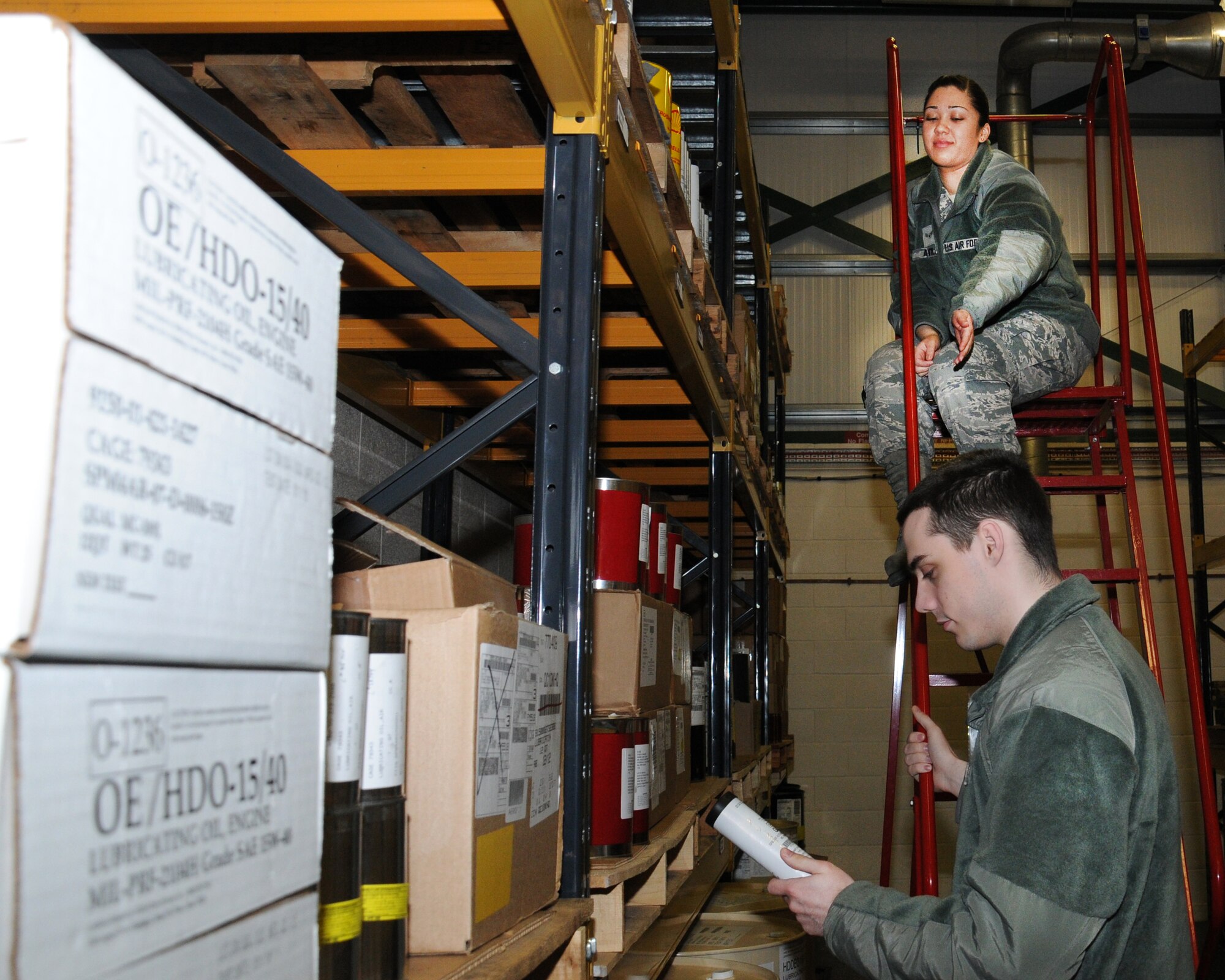 Airman 1st Class Alyssa Avila, from Monterey, Calif., top, and Airman 1st Class Joshua Kannegiesser, from Brunswick, Md., both 100th Logistics Readiness Squadron hazardous materials pharmacy technicians inventory equipment and stock Feb. 20, 2013, at RAF Mildenhall, England. The shop supports more than 48 maintenance organizations. (U.S. Air Force photo by Gina Randall/Released)