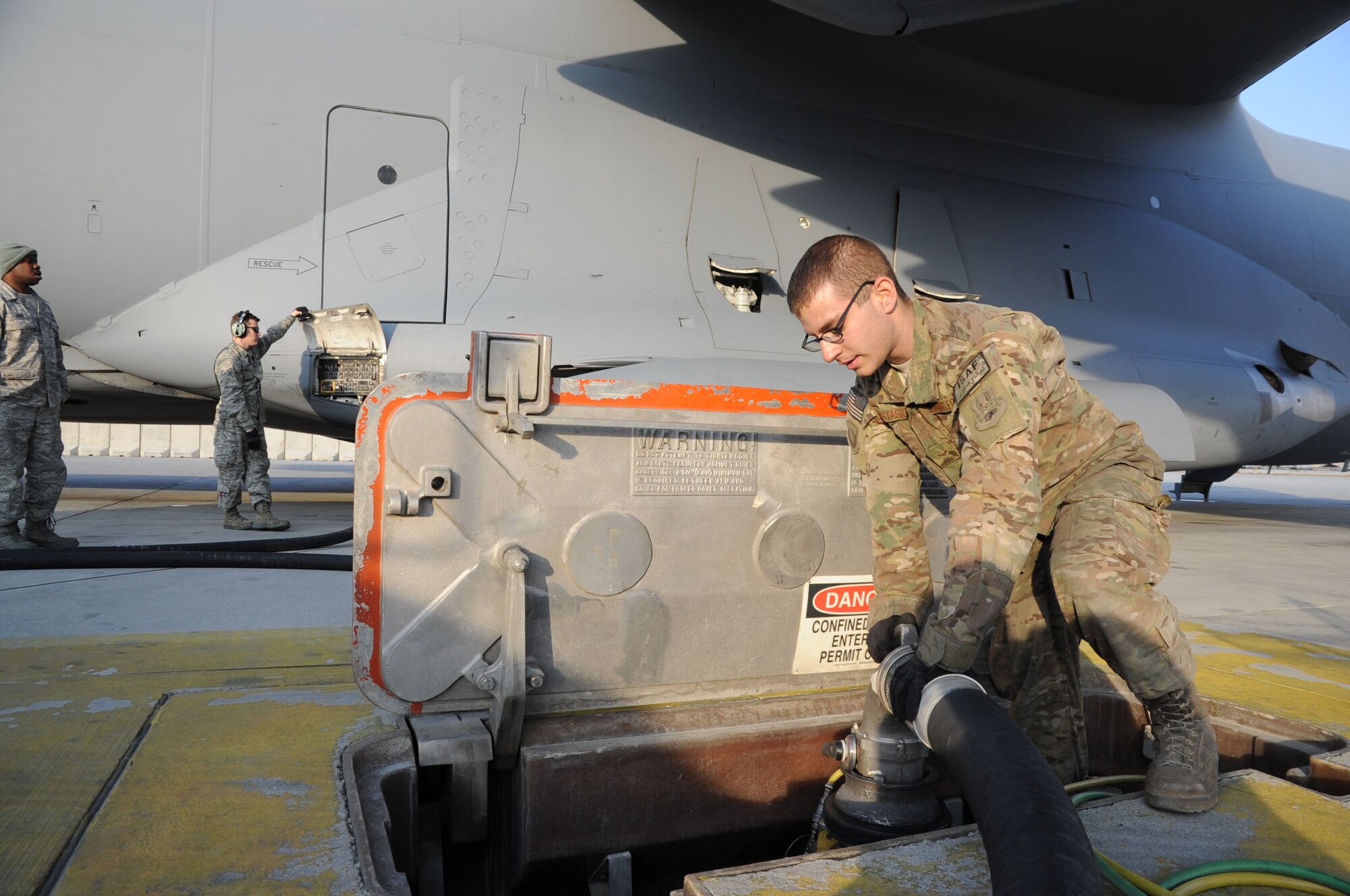 Airman 1st Class David Anastasio, 455th Expeditionary Logistics Readiness Squadron fuels systems distribution operator, connects a fuel hose to the underground hydrant system on Bagram Airfield, Afghanistan, Feb. 20, 2013. The 455th ELRS Petroleum, Oil and Lubricants section refuels an average of 135 aircraft every day. (U.S. Air Force photo/Staff Sgt. David Dobrydney)