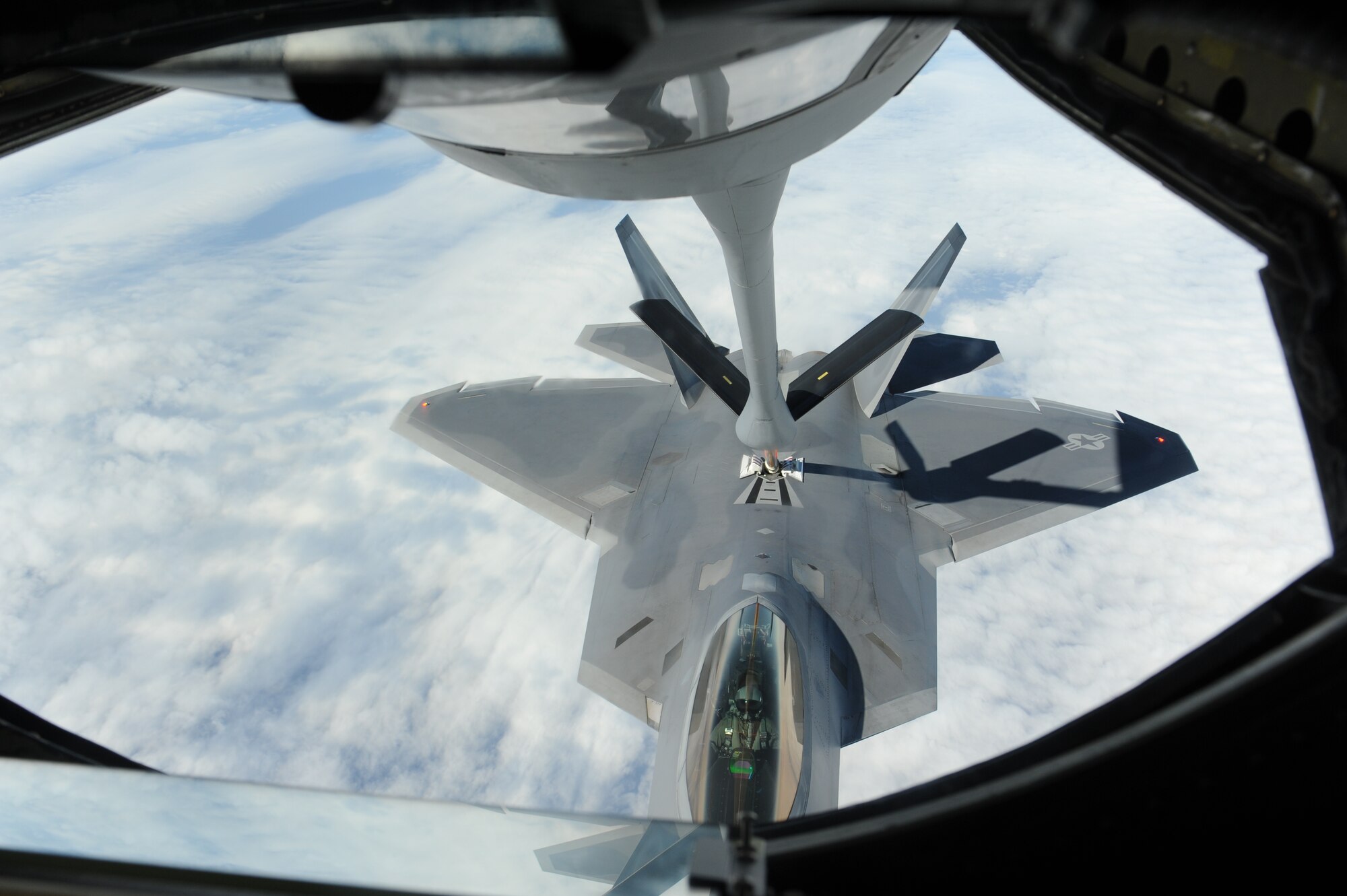 A U.S. Air Force KC-135 Stratotanker refueling aircraft refuels an F-22 Raptor fighter jet during a training sortie near Kadena Air Base, Japan, Feb. 19, 2013. Raptors from Joint Base Langley-Eustis, Va., are deployed to Kadena to demonstrate the continued U.S. commitment to fulfill security responsibilities throughout the Western Pacific and to maintain peace in the region. (U.S. Air Force photo/Airman 1st Class Malia Jenkins)