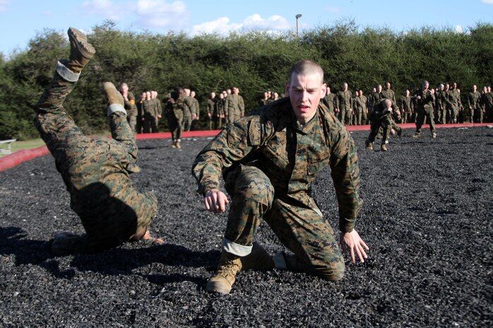 Recruits of Company F, 2nd Recruit Training Battalion, practice the forward shoulder roll aboard Marine Corps Recruit Depot San Diego, Jan. 28. The forward shoulder roll is a technique that can be used to lesson the force of falling forward and prevent injury. 