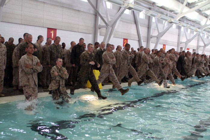 Recruits of Company L, 3rd Recruit Training Battalion, dive into a pool for an approximately 25-meter assesment swim aboard Marine Corps Recruit Depot San Diego Feb. 11. The 25-meter swim was done before any exercises were conducted to ensure weaker swimmers recieved extra time to better their swimming skills. 