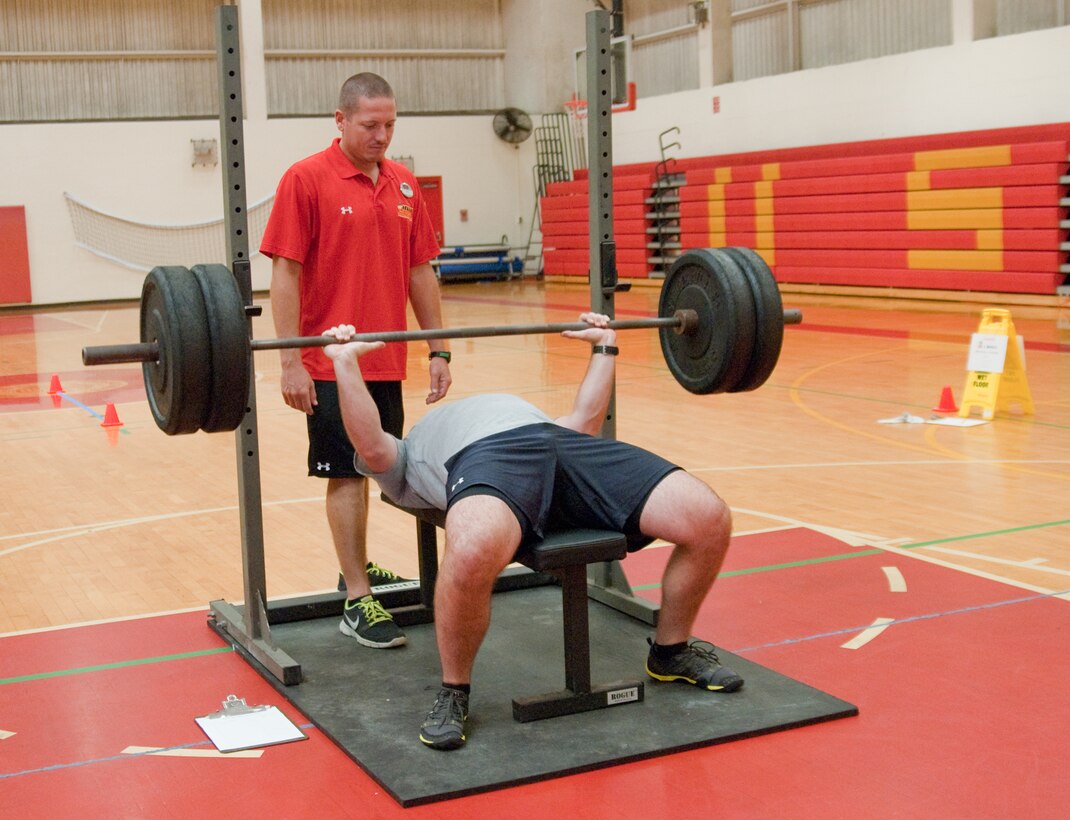 MARINE CORPS BASE HAWAII - Petty Officer 2nd Class Shane Miller, a Naval aircrewman with Helicopter Anti-Submarine Squadron Light 37, attempts the bench press portion of the Semper Fit Combine at the Semper Fit Center, Feb. 20, 2013. Jason Cutitta, a trainer with Semper Fit, spotted Miller, and kept track of his repetitions. The inaugural event, which ran from Feb. 20 to 22, features six different stations used in a National Football League combine. Football players hoping to try out for the NFL must be tested in a combine. As the NFL holds its official combine this week, Semper Fit is following suit to give Marine Corps Base Hawaii personnel a chance to see how they compare to the professionals. (U.S. Marine Corps photo by Kristen Wong)