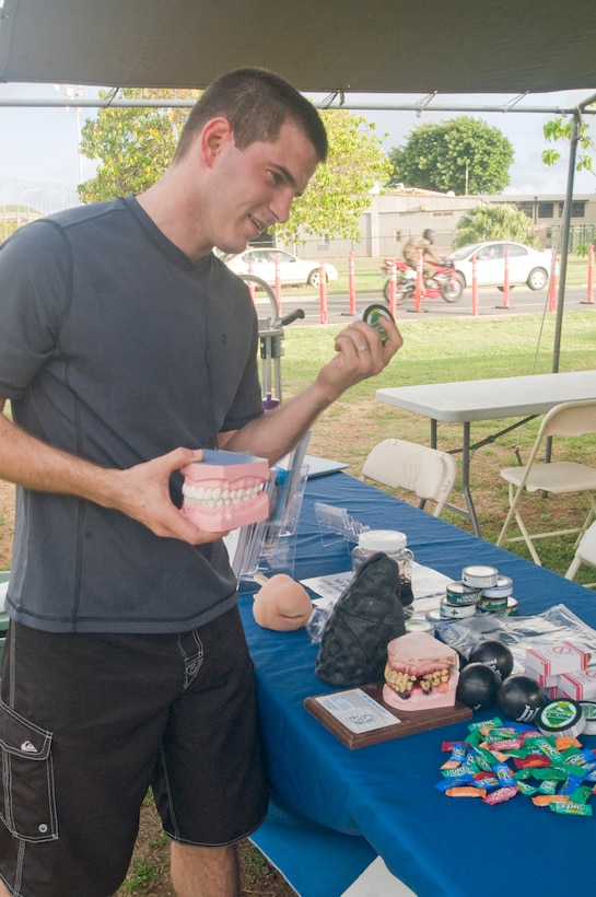 MARINE CORPS BASE HAWAII — Petty Officer 2nd Class Josiah Halstead, aviation electronics technician, Marine Aviation Logistics Squadron 24, examines subsitutes for smokeles tobacco, Nov. 7, 2011. Marine Corps Base Hawaii helps service members and their families stop using smokeless tobacco with several events including Through with Chew Week, held from Feb. 17 to 23. The MCB Hawaii Health Promotion office featured a display about the dangers of tobacco use during the Great American Spit Out, at Anderson Hall Dining Facility, Thursday. (Official U.S. Marine Corps photo by Christine Cabalo/Released)