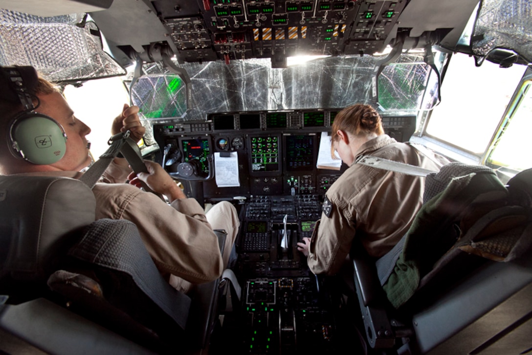 130209-M-BY384-008 CAMP LEMONNIER, DJIBOUITI (Feb. 9, 2013)  Captain Reid Houck, co-pilot, VMGR-352, 15th Marine Expeditionary Unit, fastens his seatbelt while Maj. Angel Hooper, aircraft commander, VMGR-352, 15th MEU, conducts a pre-flight inspection in the cockpit of a KC-130 Hercules before beginning an aerial refueling mission, Feb. 9.  The 15th MEU is deployed as part of the Peleliu Amphibious Ready Group as a U.S. Central Command theater reserve force, providing support for maritime security operations and theater security cooperation efforts in the U.S. 5th Fleet area of responsibility. 