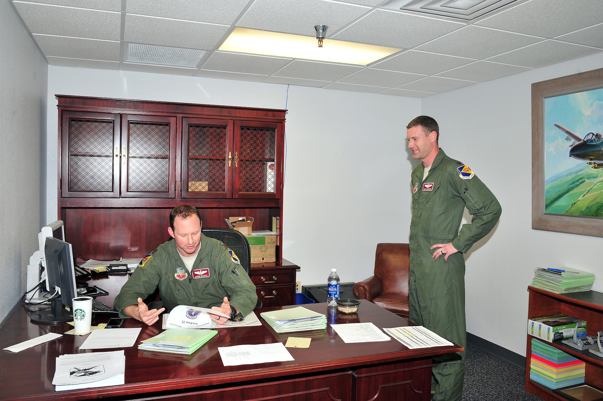 U.S. Air Force Maj Aaron Celusta (left), 355th Operations Group chief of standardization and evaluation, reviews paperwork with Maj Matt Kaercher, 355th Operations Group A-10 pilot on Davis-Monthan Air Force Base, Ariz., Feb 21, 2013. The 355th OG employs 83 A-10C aircraft and an AN/TPS-75 radar system. (U.S. Photo by Airman 1st Class Josh Slavin/Released)
