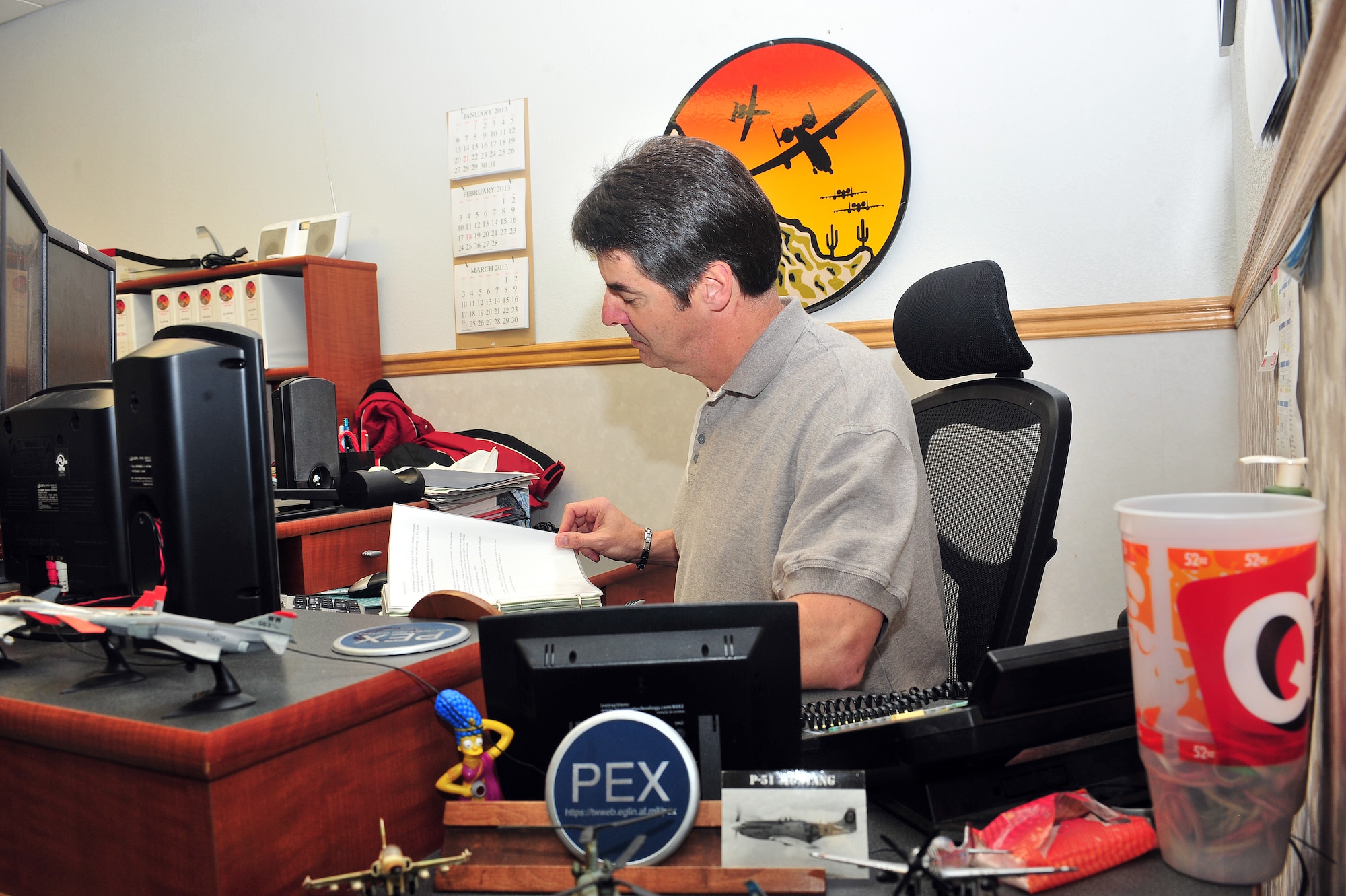 Paul Richard, 355th Operations Group Patriot Excalibur software administrator, reviews a folder on Davis-Monthan Air Force Base, Ariz., Feb 21, 2013. Patriot Excalibur software enables full-scale deployment of battle-ready units. (U.S. Photo by Airman 1st Class Josh Slavin/Released)