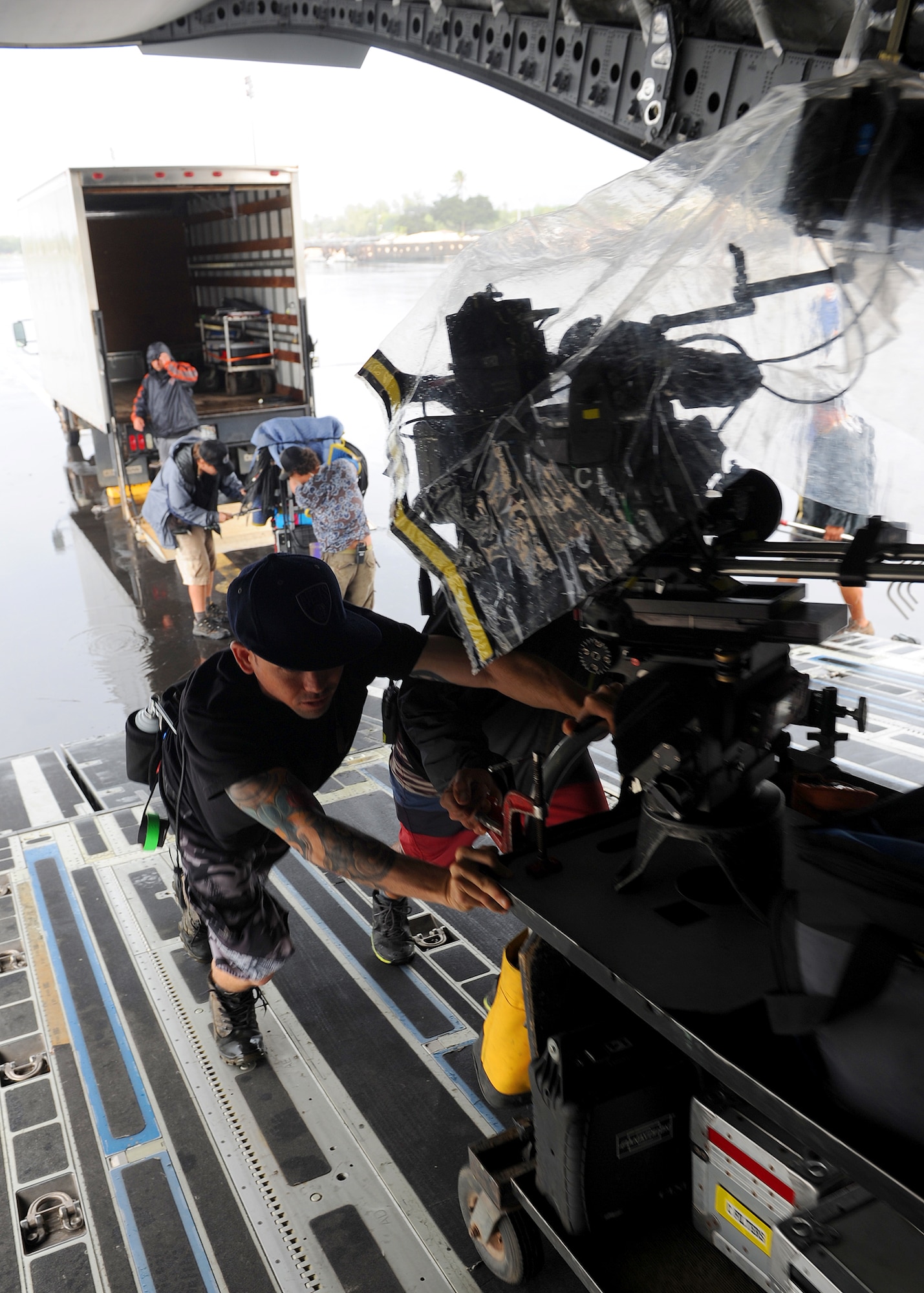 Production crew members from “Hawaii Five-0” load a camera aboard a C-17 Globemaster at Joint Base Pearl Harbor-Hickam, Feb. 21, 2013.  The crew and cast were on scene to shoot a portion of an upcoming episode. (U.S. Air Force photo/Tech. Sgt. Jerome S. Tayborn)