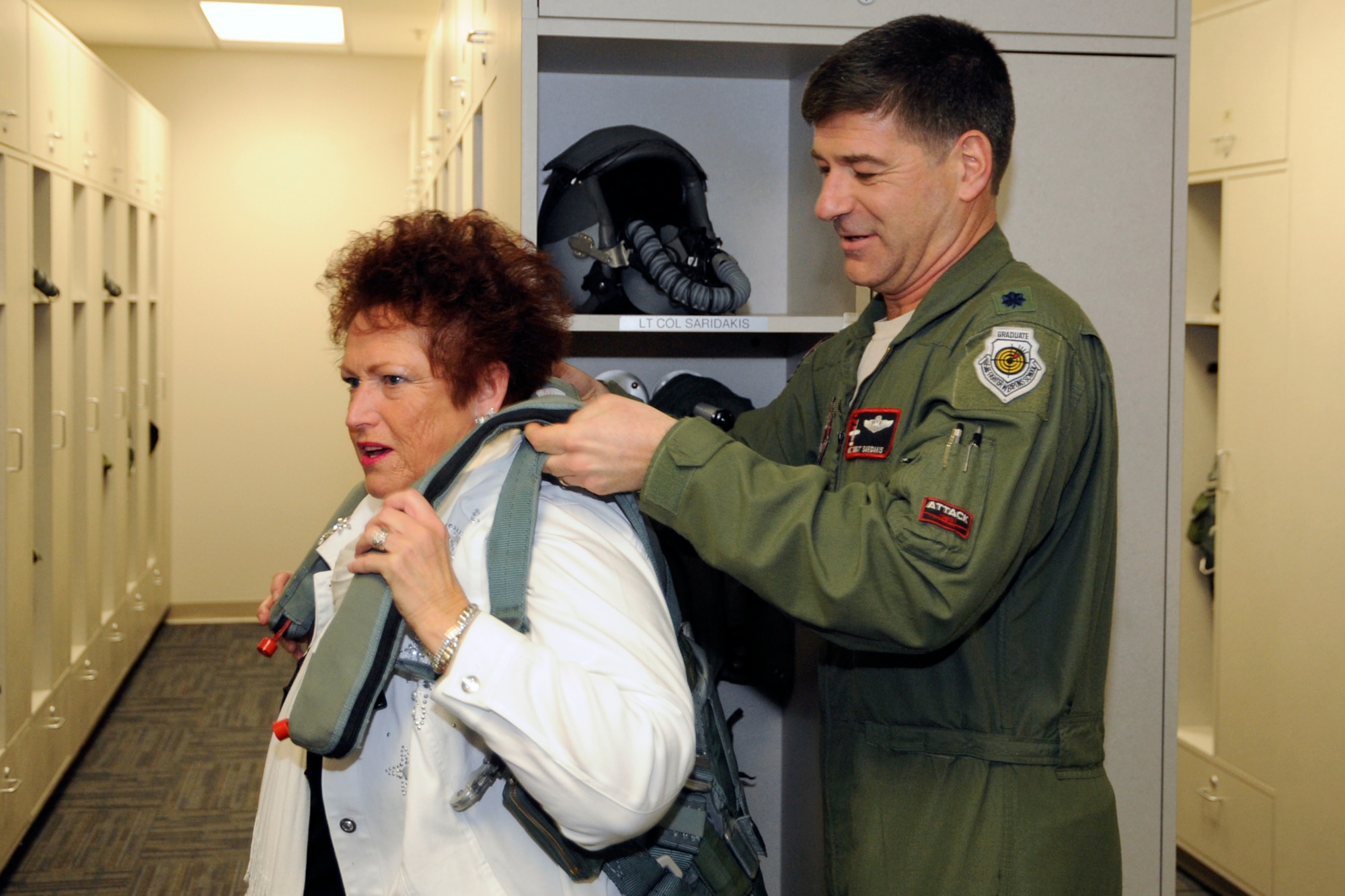 City of Mt. Clemens Mayor Barbara Dempsey tries on a Life Preserver Unit-34-P with a little help from Lt. Col. Emmanuel Saridakis, 107th Fighter Squadron Commander, following a ribbon cutting for the new $6.6 million Operations Facility on February 22 at Selfridge Air National Guard Base, Mich.  The new building will be home to the Operations Group command staff, the 107th Fighter Squadron and the 127th Operations Support Flight.  (photo by John S. Swanson)
