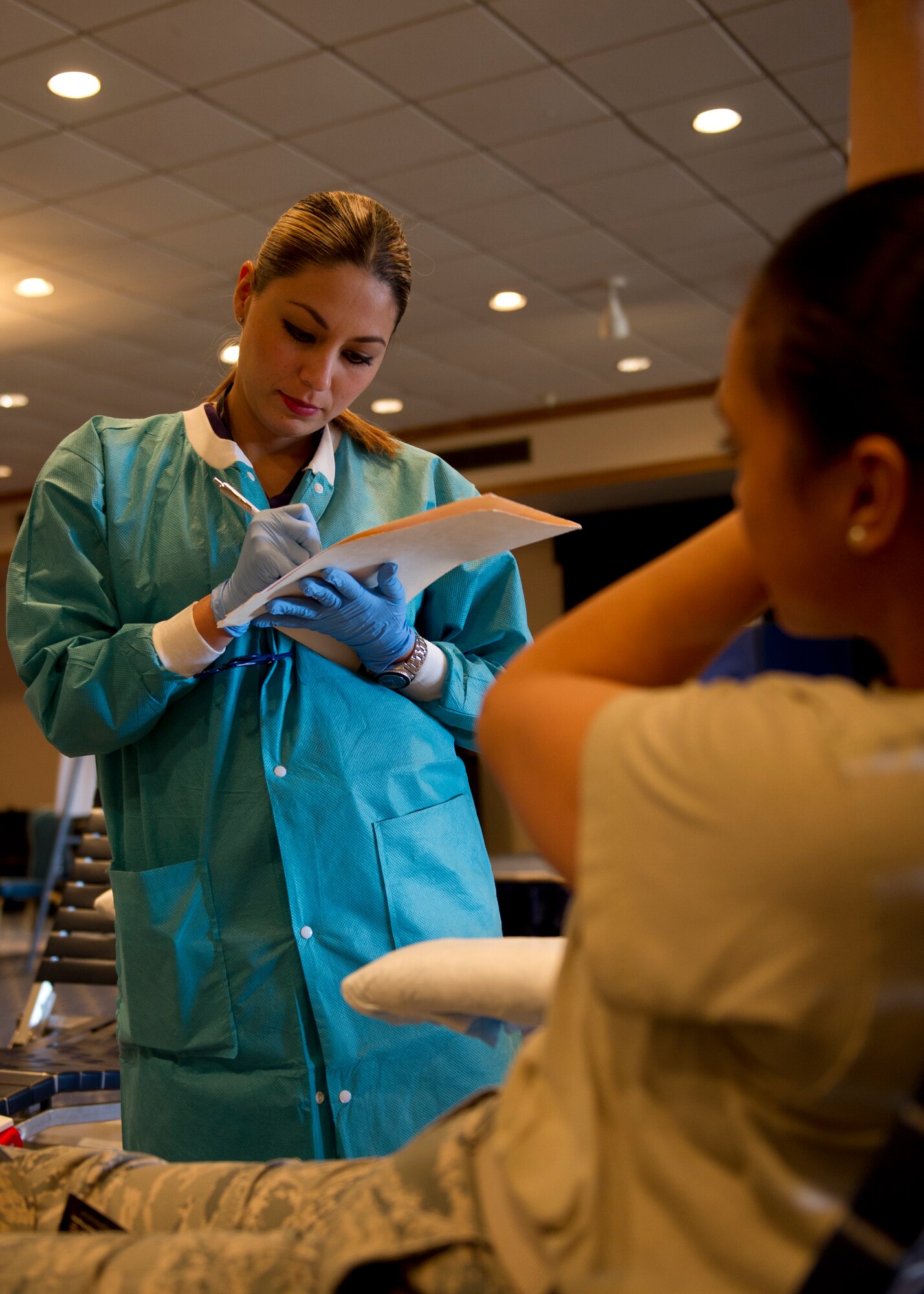 Brenda Islas, William Beaumont Army Medical Center medical technician, annotates information about Senior Airman Yesenia Benjamin’s blood donation after giving a donation during an Armed Services Blood Program blood drive at Holloman Air Force Base, N.M., Feb. 20. Benjamin is a 49th Aerospace Medicine Squadron public health technician. Holloman AFB donated 32 units of blood during the drive. One donation can save three lives.  (U.S. Air Force photo by Senior Airman Kasey Close/Released)