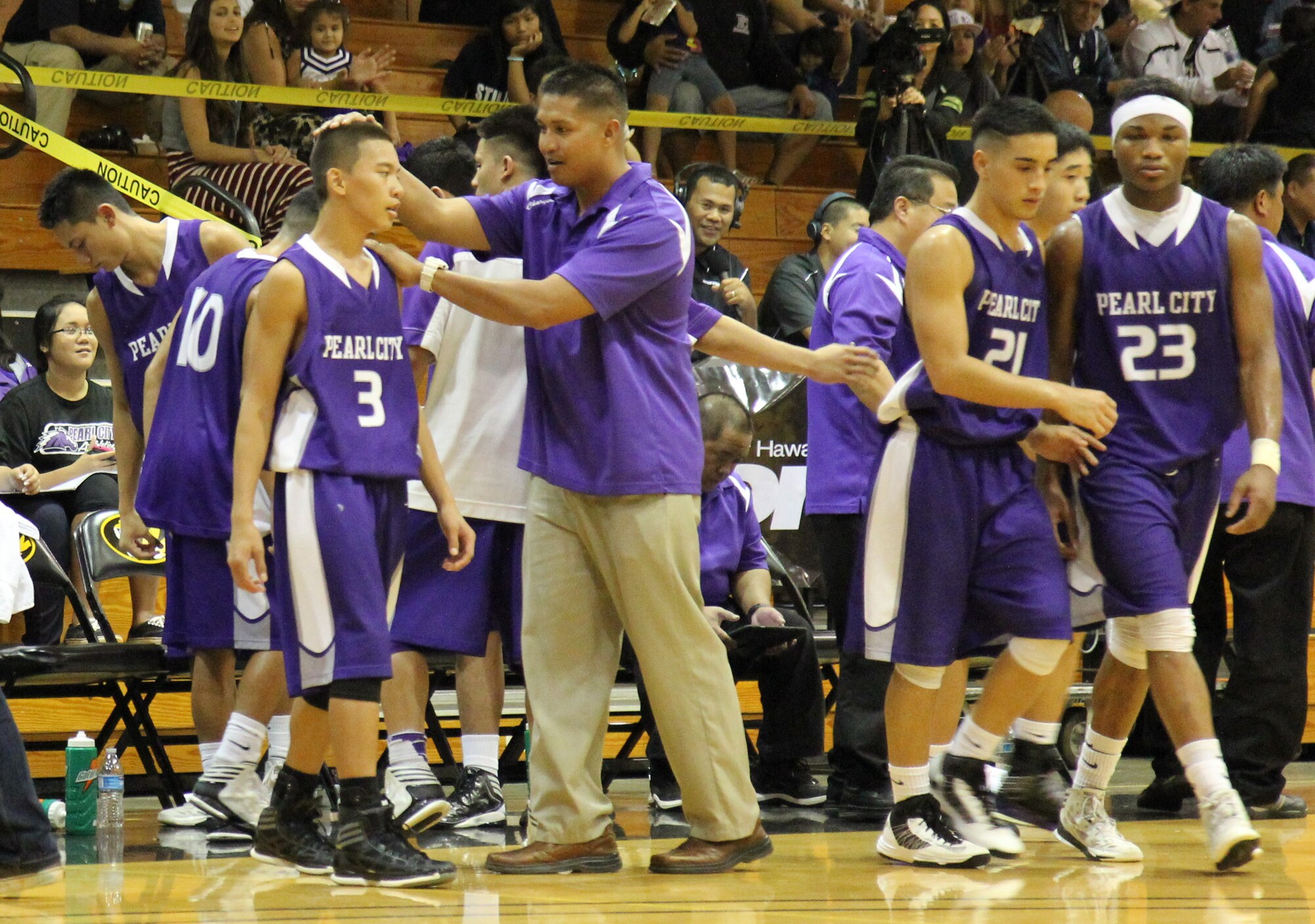 Tech. Sgt. Randolph A. Soriano, center, a heating, ventilation and air conditioning technician with the 624th Civil Engineering Squadron, 624th Regional Support Group, Joint Base Pearl Harbor-Hickam, Hawaii, gives one of his players a pat on the head for encouragement during a Hawaii High School Athletic Association Division I State Basketball Championship Tournament game at President William McKinley High School, Honolulu, Hawaii, Thursday, Feb. 21, 2013. Tech. Sgt. Soriano, a former player for the Pearl City Chargers, Pearl City, Hawaii, now serves as an assistant coach at his alma mater as they make a run in the state tournament for the second year in a row. (U.S. Air Force photo/Tech. Sgt. Phyllis E. Keith)