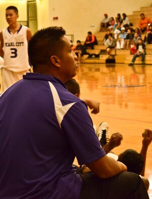 Tech. Sgt. Randolph A. Soriano, a heating, ventilation and air conditioning technician with the 624th Civil Engineering Squadron, 624th Regional Support Group, Joint Base Pearl Harbor-Hickam, Hawaii, checks the scoreboard during a boys high school basketball game at Pearl City High School, Pearl City, Hawaii, Wednesday, Feb. 13, 2013. Tech. Sgt. Soriano, a former player for the Pearl City Chargers, now serves as an assistant coach at his alma mater as they make a run in the Hawaii High School Athletic Association Division I State Basketball Championship Tournament. (U.S. Air Force photo/Tech. Sgt. Phyllis E. Keith)