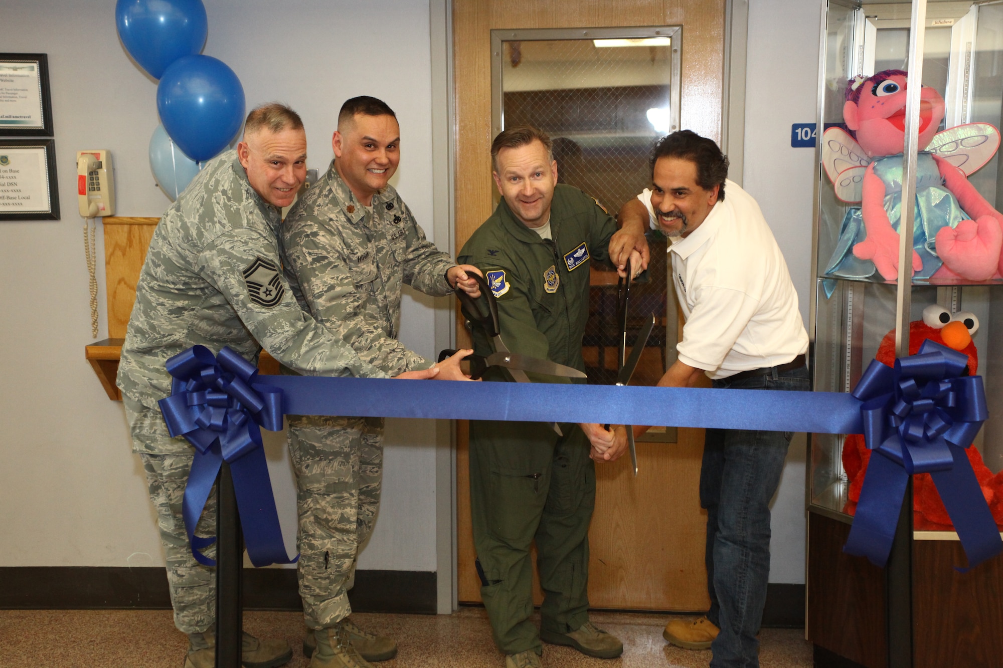 (Left) Senior Master Sgt. Kraig Ferguson, 305th Aerial Port Squadron flight superintendent for passenger services, Maj. Edward Hogan, 305th APS commander, Col. Richard Williamson, 305th Air Mobility Wing commander, and Dennis Pressey, Center Point Construction president, cut the ribbon for the newly renovated McGuire Passenger Terminal Family Lounge and Teen Room Feb. 12, 2013, on Joint Base McGuire-Dix-Lakehurst, N.J. The McGuire Passenger Terminal supports an average of more than 45,000 passengers a year, many of whom are families with children. (U.S. Air Force photo by Wayne Russell/Released)