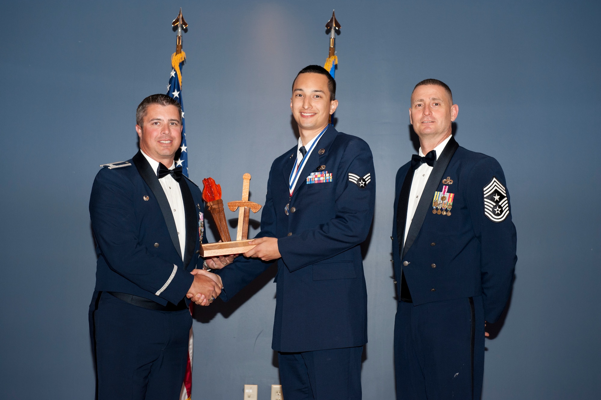 Senior Airman Kenneth Barnett, 325th Maintenance Group, receives the 2012 Team Tyndall Annual Award for Airman of the Year Feb. 20 from Col. David Graff, 325th Fighter Wing commander and Chief Master Sgt. Ray DeVite, 325th FW command chief. (U.S. Air Force photo by Lisa Norman)