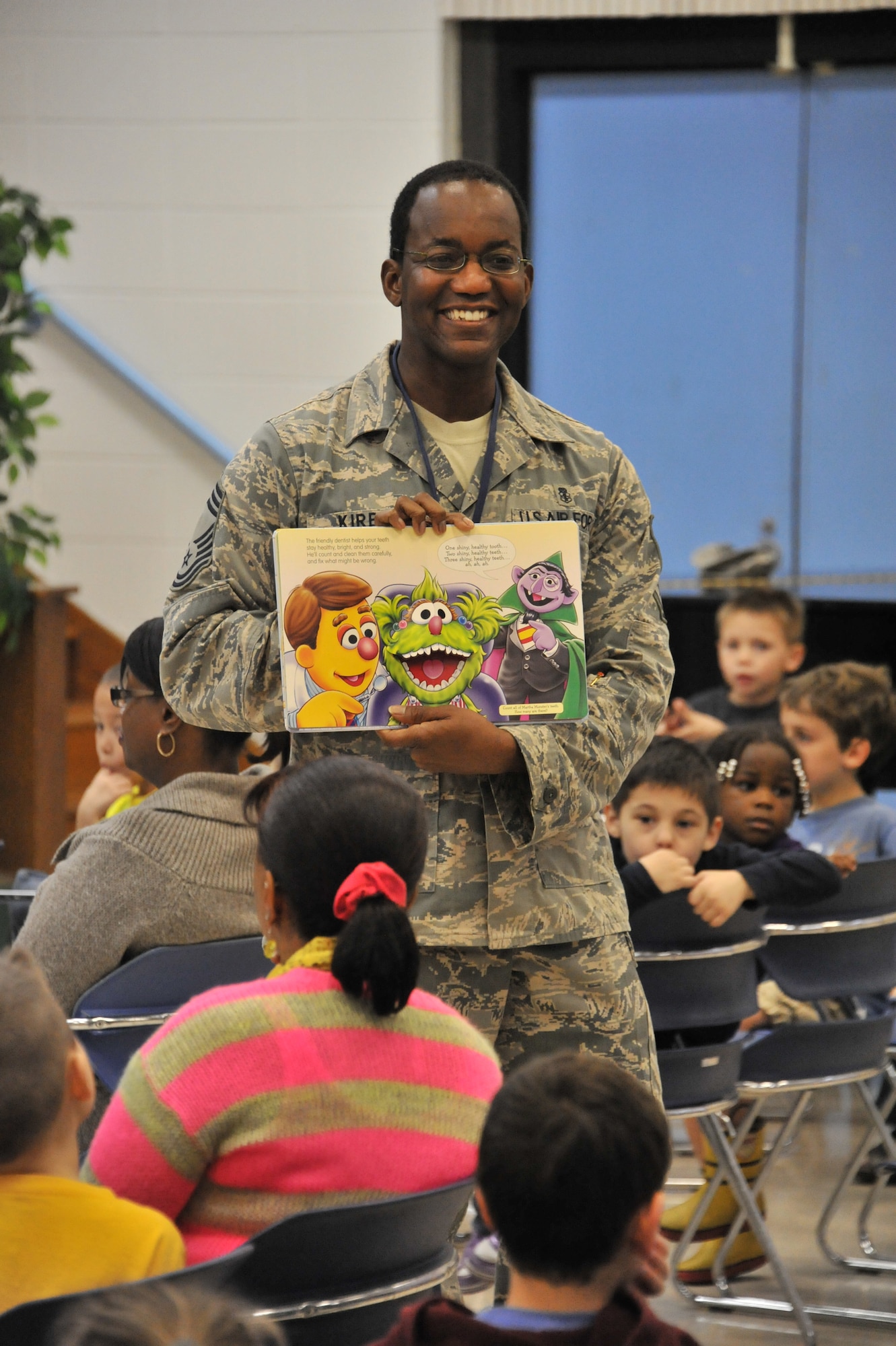 Chief Master Sgt. Lawrence Kirby, Thomas E. Barnes Center for Enlisted Education, senior enlisted leader for Air Force enlisted education, reads a book to students at Maxwell Elementary Middle School, Feb. 12. Kirby was part of a team who spent time with kids teaching them good dental habits. (U.S. Air Force photo by Airman 1st Class William Blankenship)
