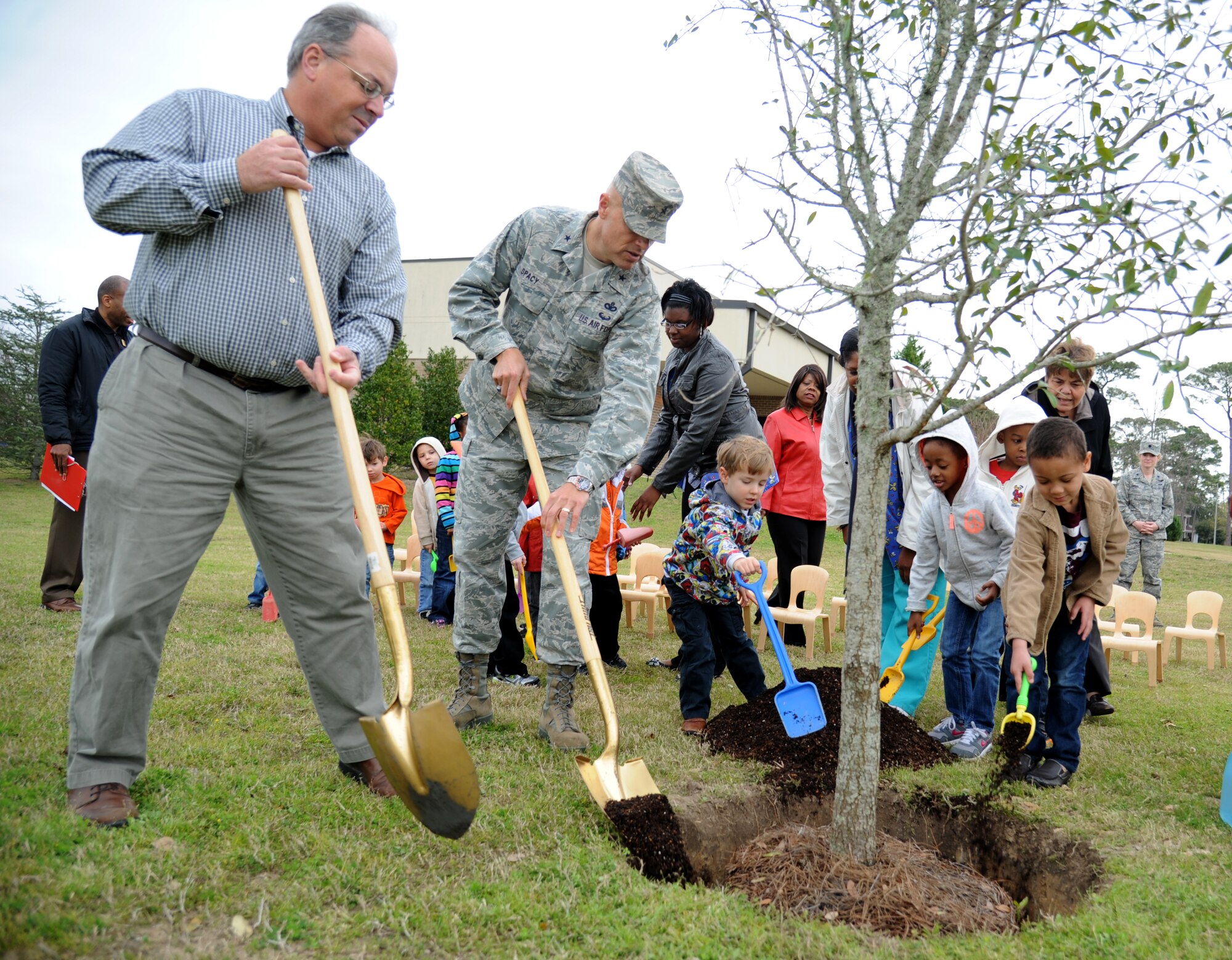 Eric Nolan, City of Biloxi arborist, and Brig. Gen. Brad Spacy, 81st Training Wing commander, plant a tree in honor of Arbor Day along with a 4-to-5-year-old class at the child development center Feb. 21, 2013, at Keesler Air Force Base, Miss.  The Tree City USA award was also presented to Keesler for the 20th consecutive year for its tree management program.  (U.S. Air Force photo by Kemberly Groue)