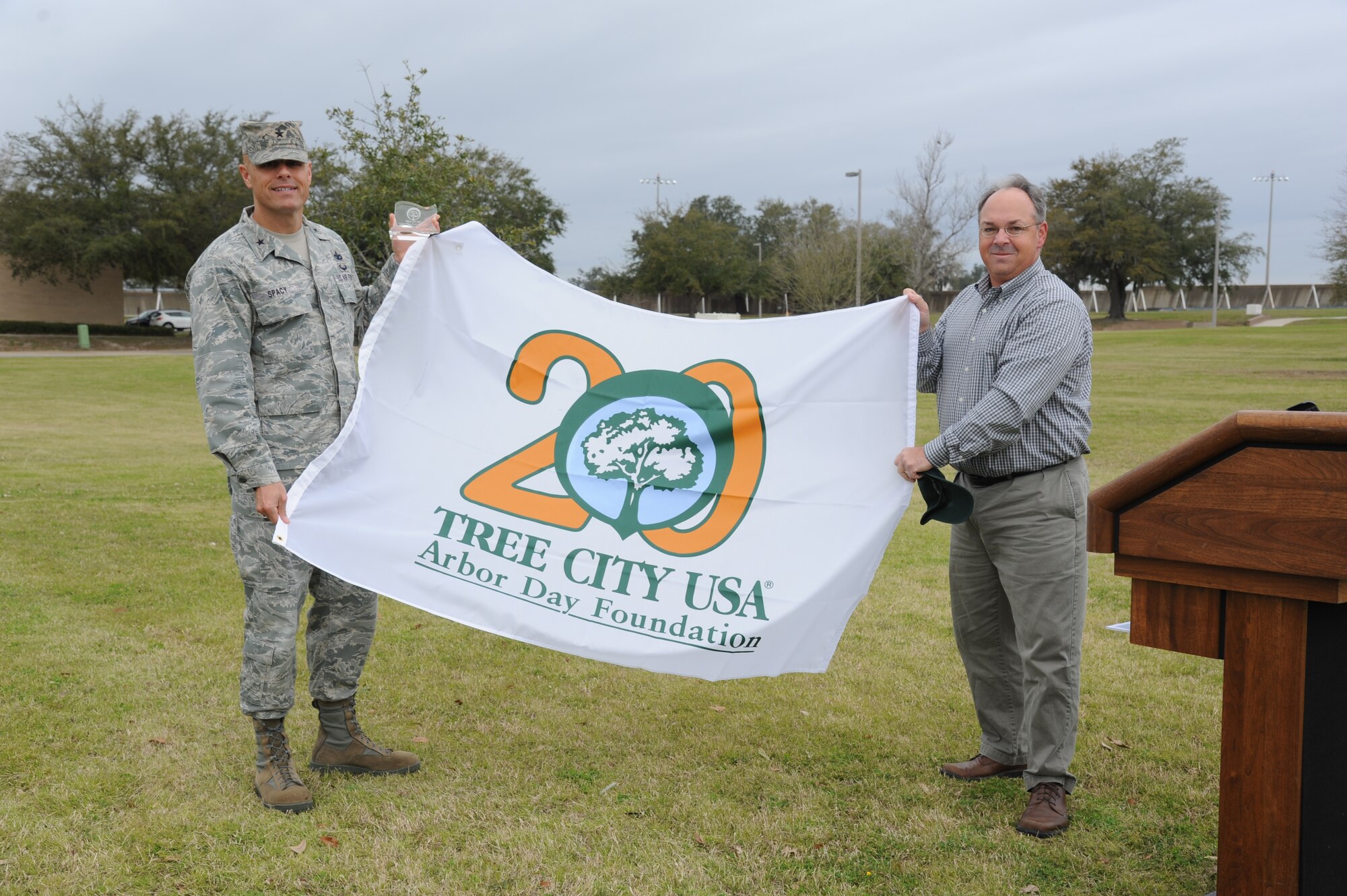 Brig. Gen. Brad Spacy, 81st Training Wing commander, is presented the Tree City USA award by Eric Nolan, City of Biloxi arborist, during a tree-planting ceremony  for Arbor Day Feb. 21, 2013, at the child development center at, Keesler Air Force Base, Miss.  The award was presented to Keesler for the 20th consecutive year for its tree management program.  (U.S. Air Force photo by Kemberly Groue)